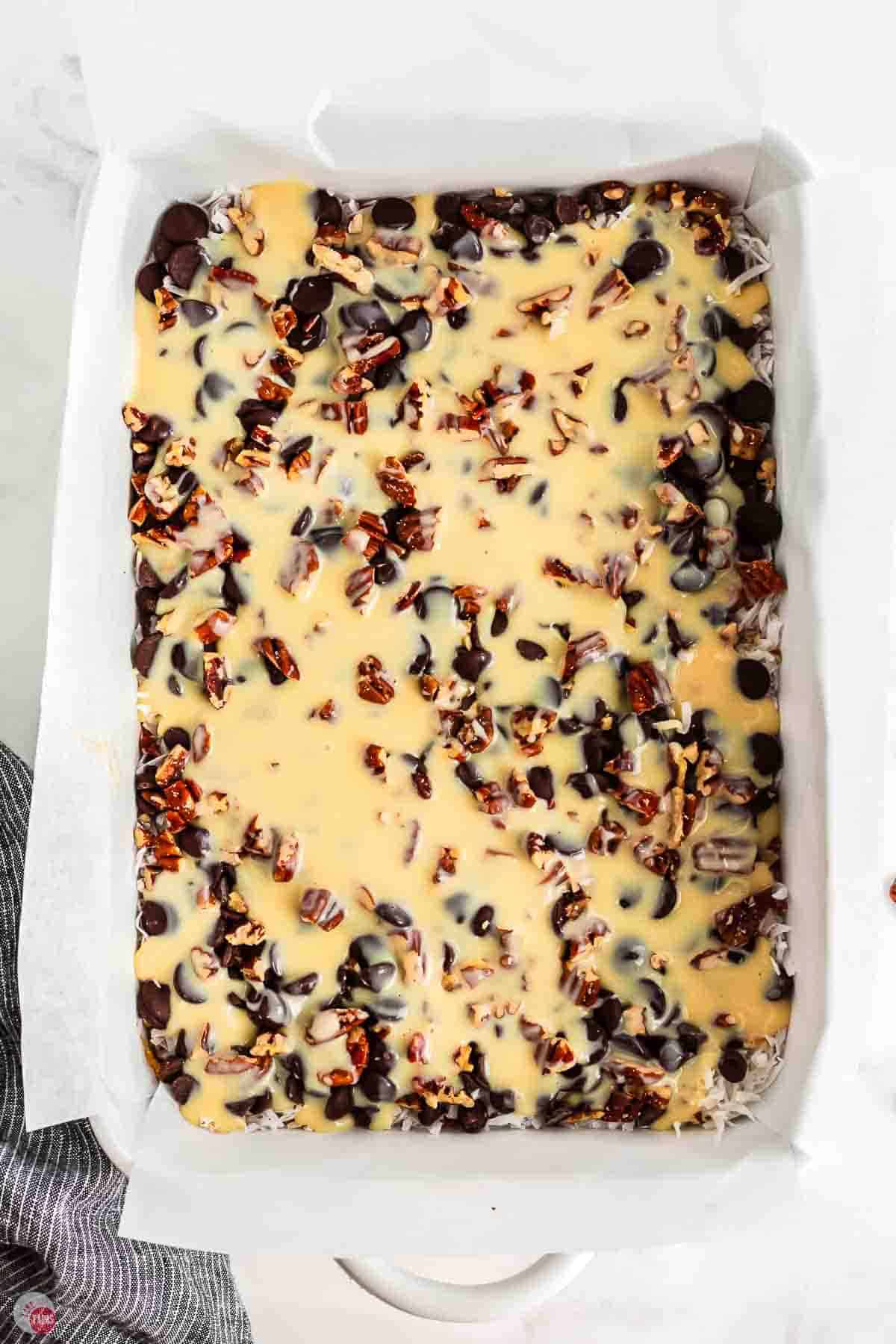 baking dish with parchment paper and sweetened condensed milk on it