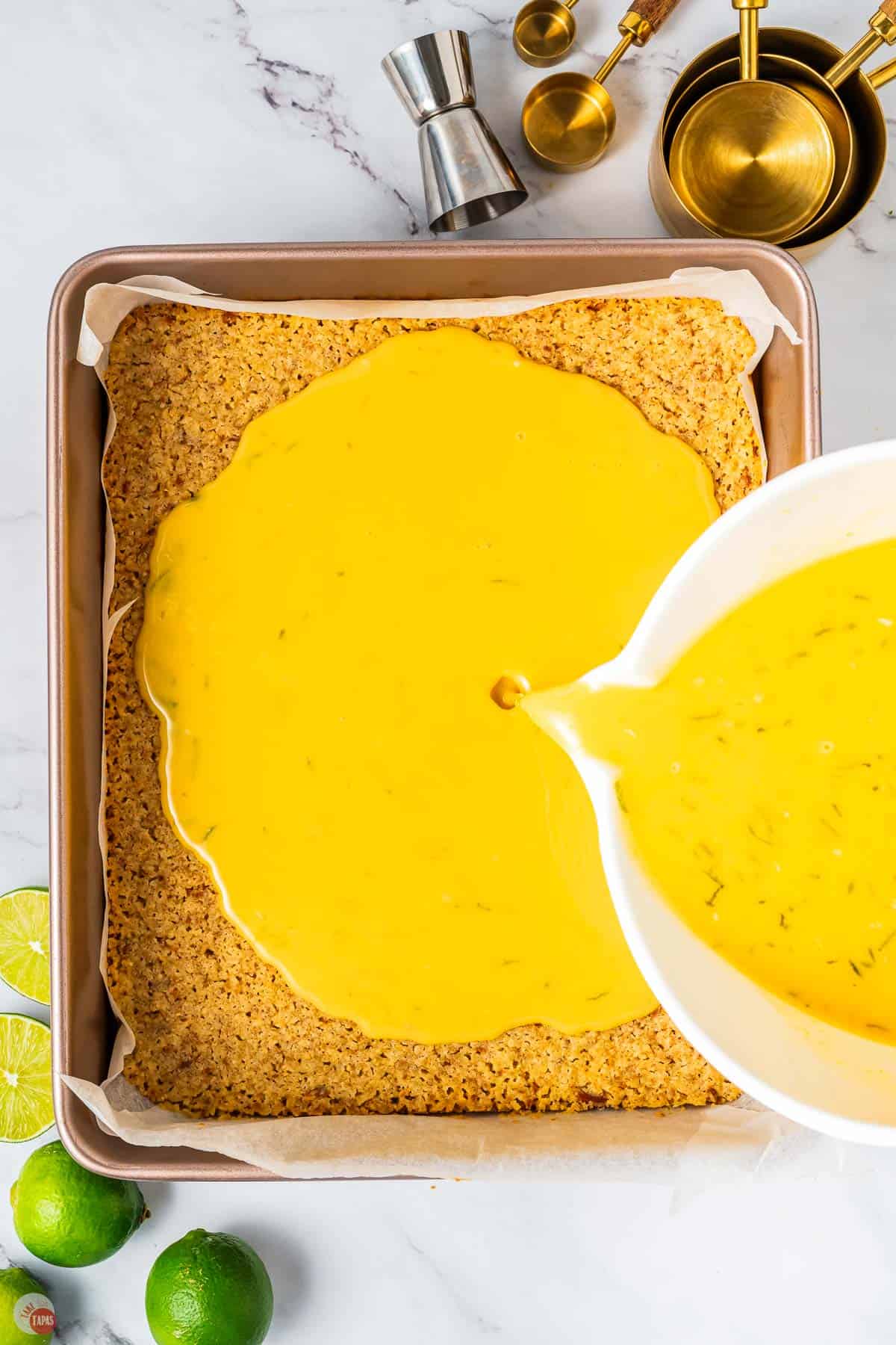 white bowl pouring lime filling on a crust
