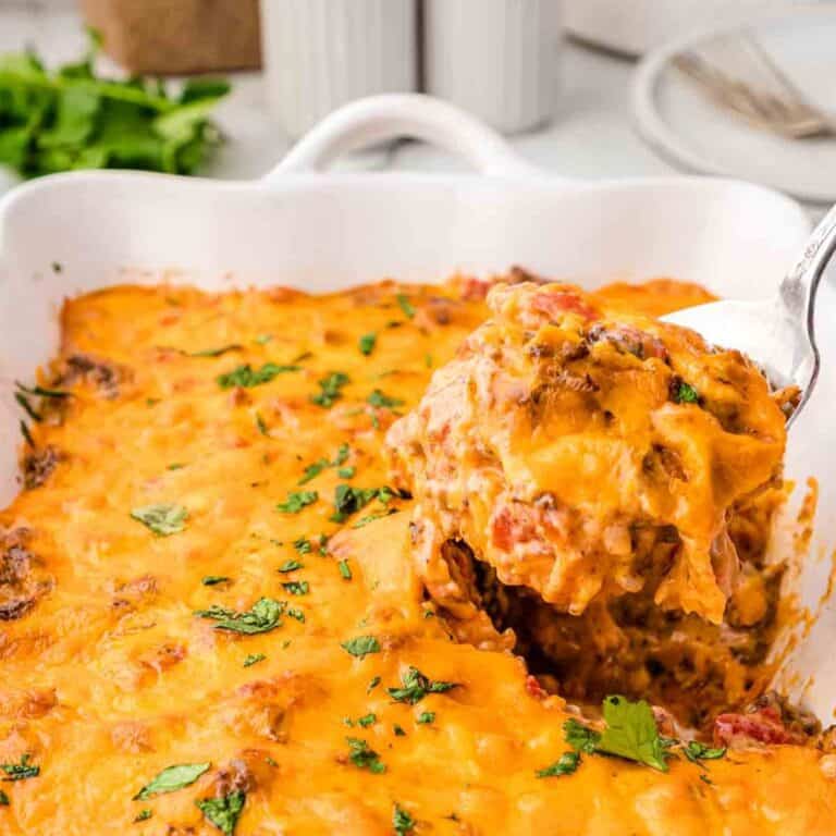 spoon scooping a cheesy casserole out of a dish