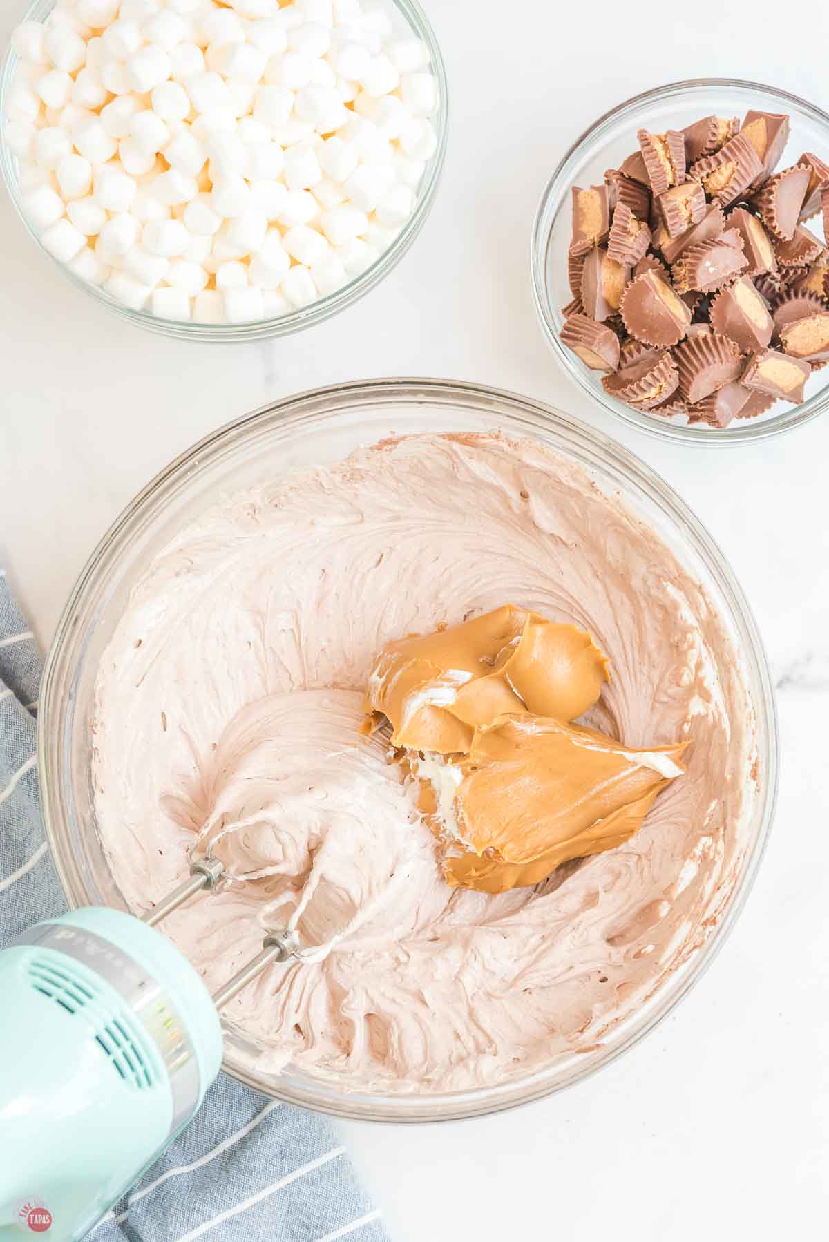 whipped topping and a scoop of peanut butter in a clear bowl