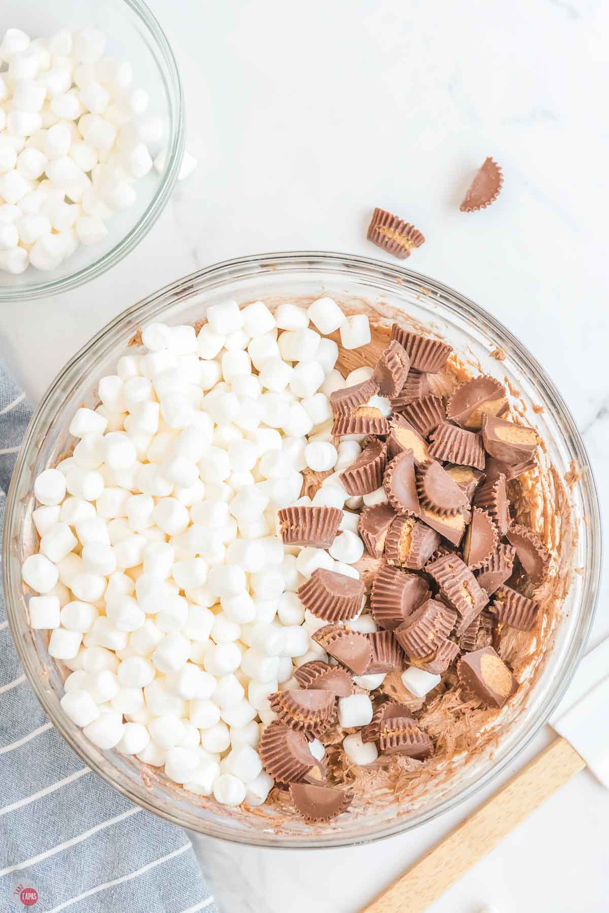 clear mixing bowl with mini marshmallows and chopped peanut butter cups on top