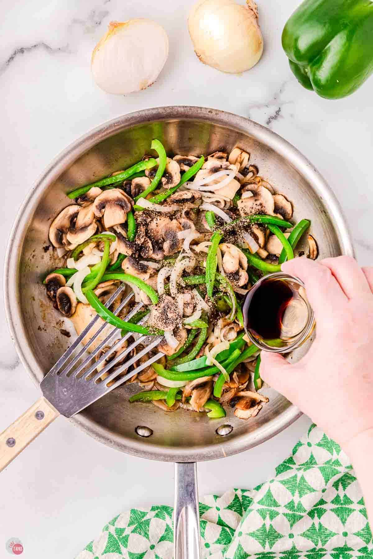 sliced peppers and onions cooking in a skillet