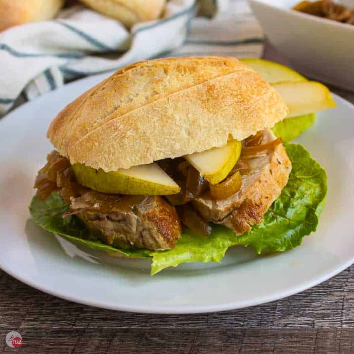 pork tenderloin slider on a white plate with lettuce