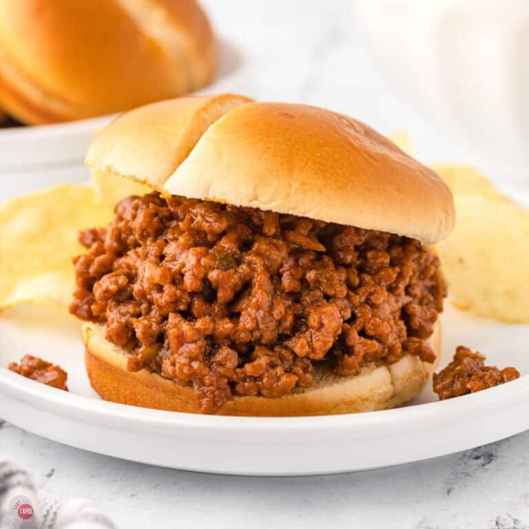 white plate with sloppy joe sandwich and potato chips