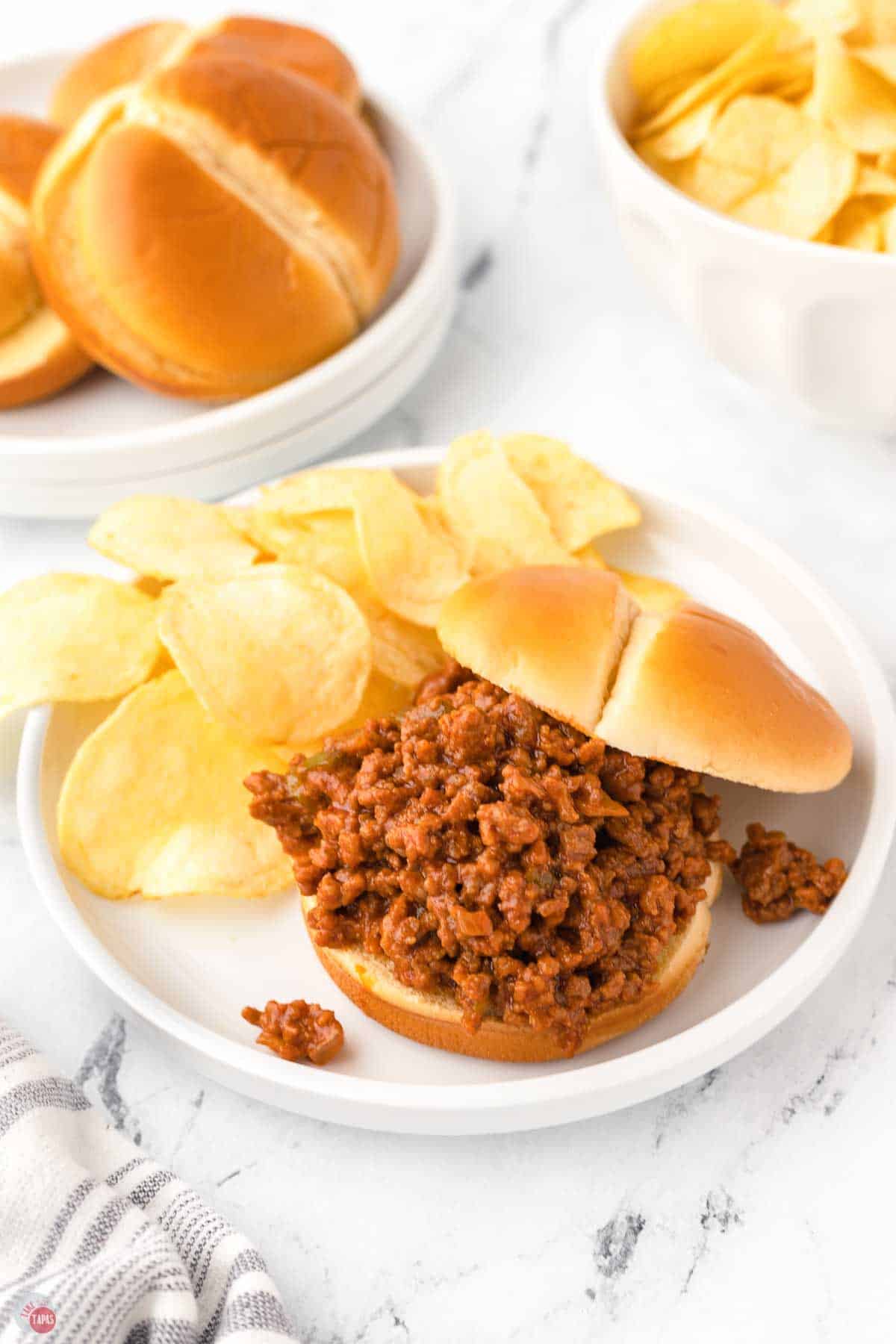 white plates with sandwiches and chips