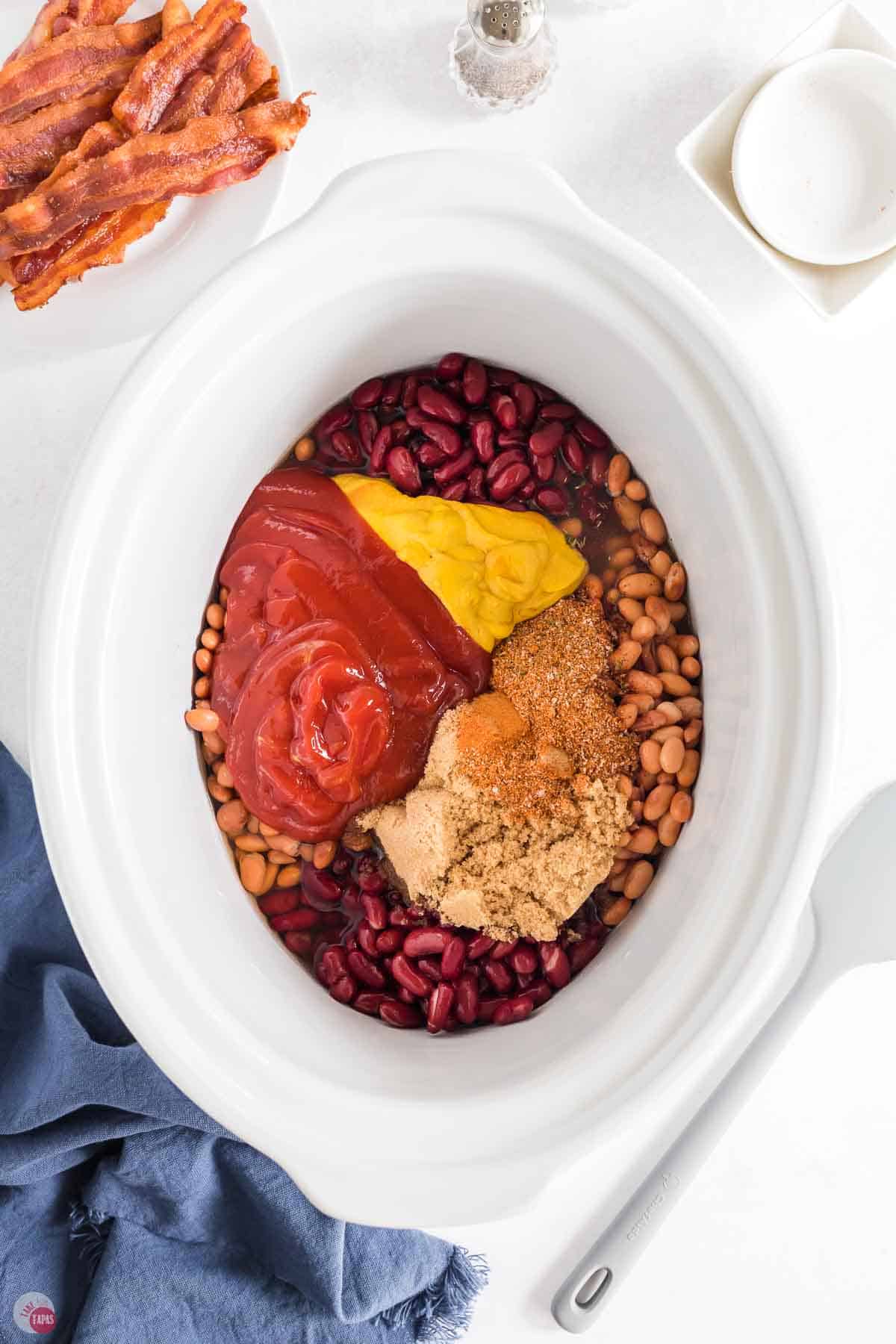 mustard, ketchup, and beans in a white bowl