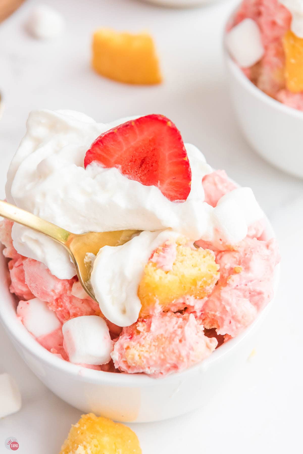 gold spoon with cake and whipped topping