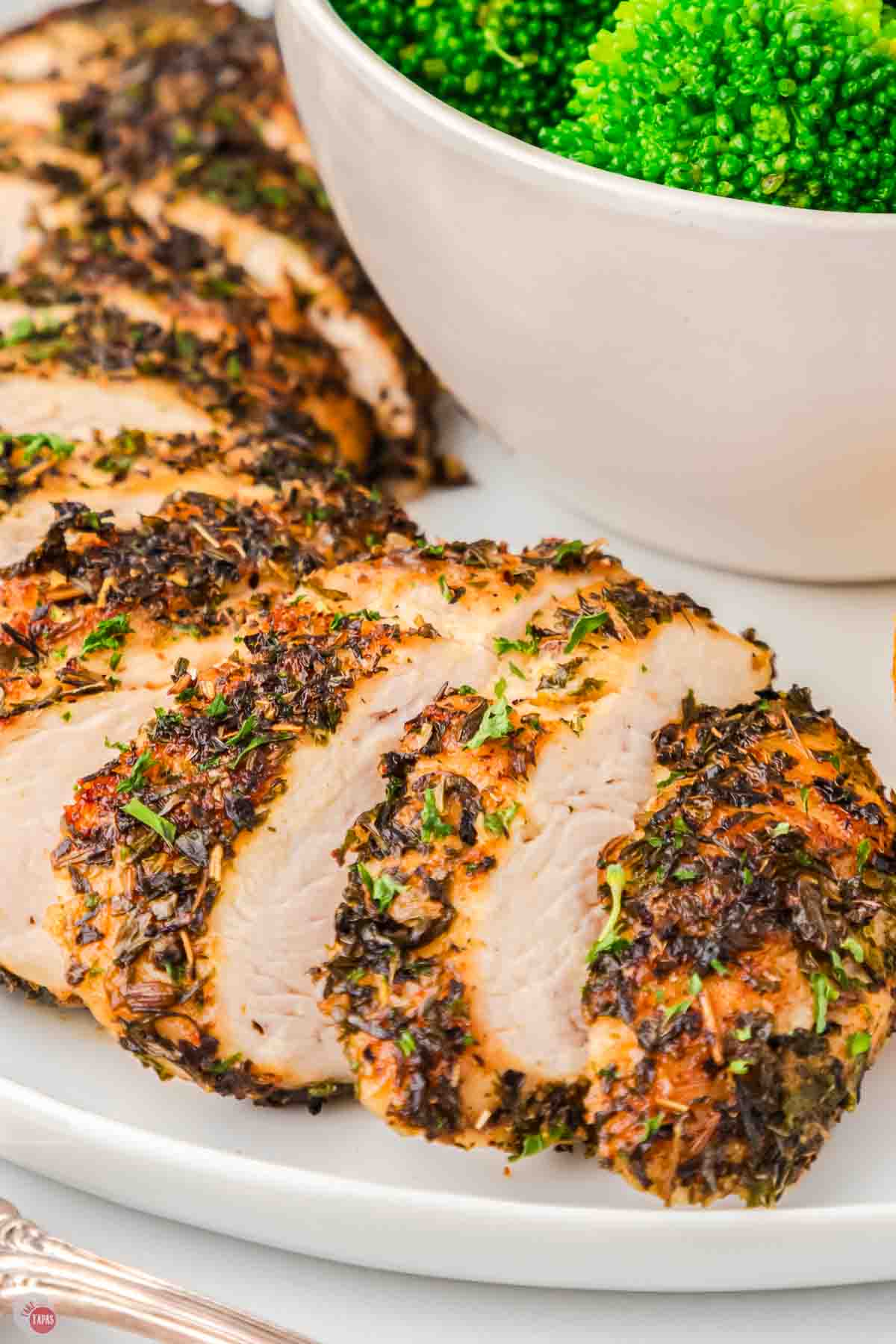 slices of herb chicken on a plate