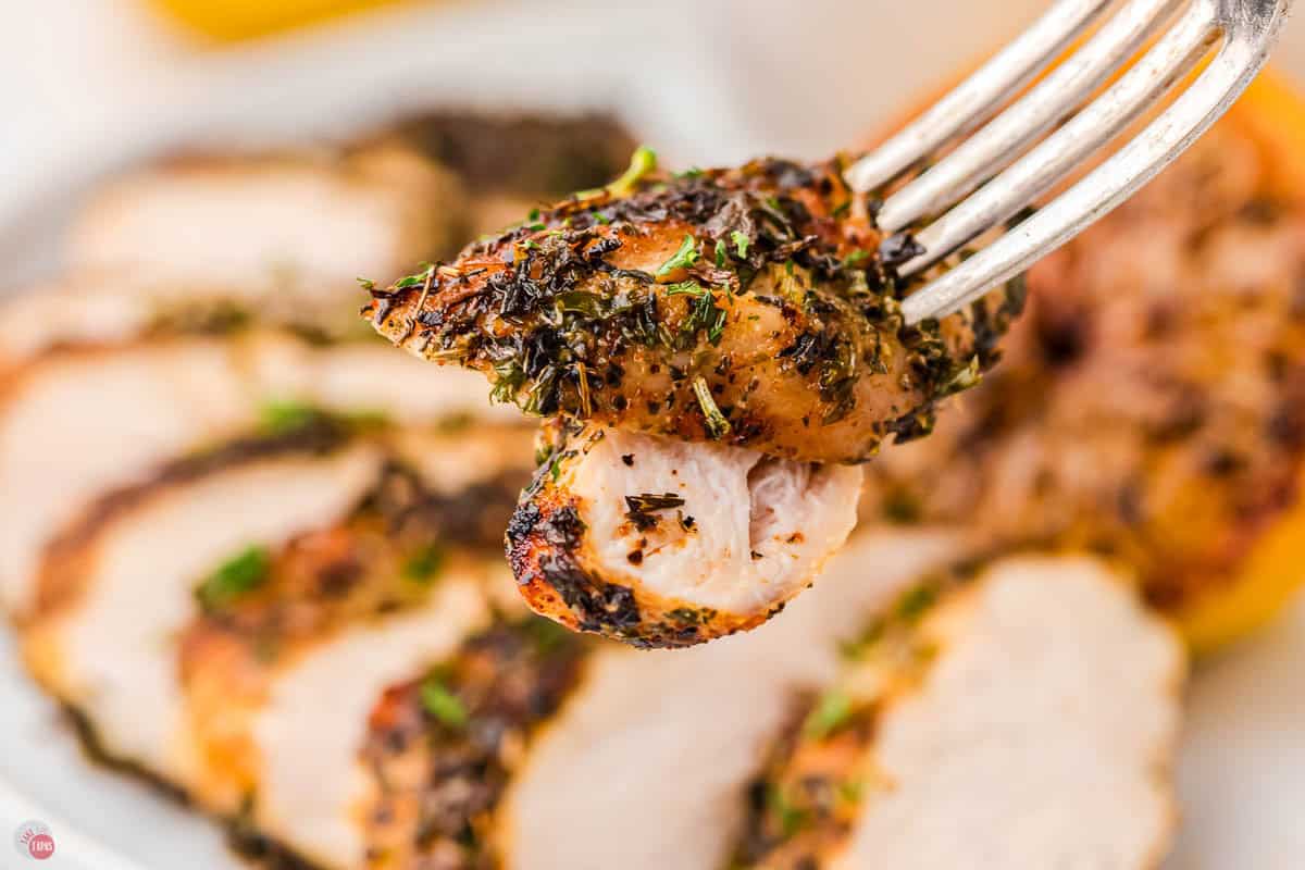 bite of chicken with herbs on it