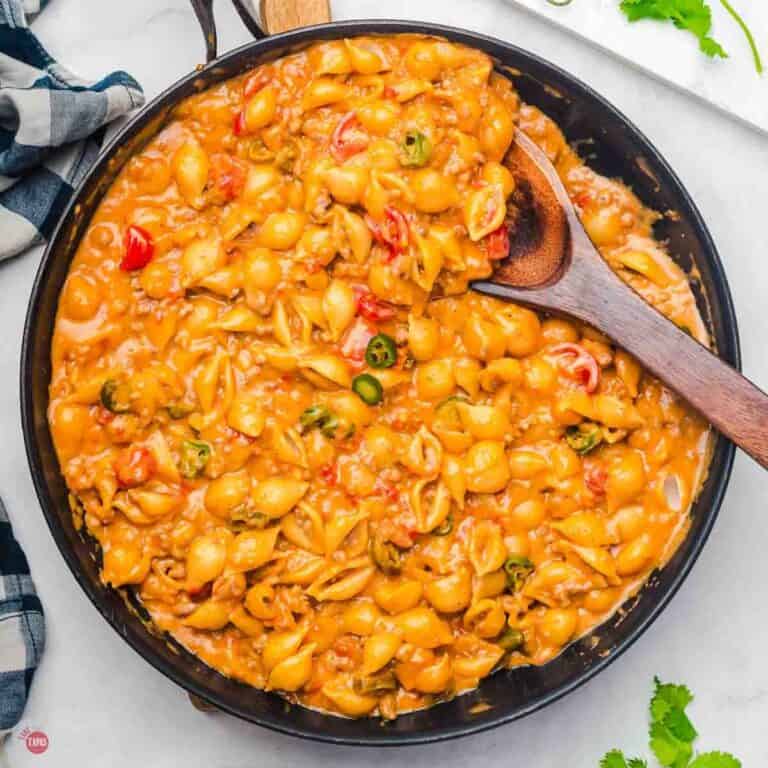 skillet of Velveeta taco mac and cheese with a wood spoon