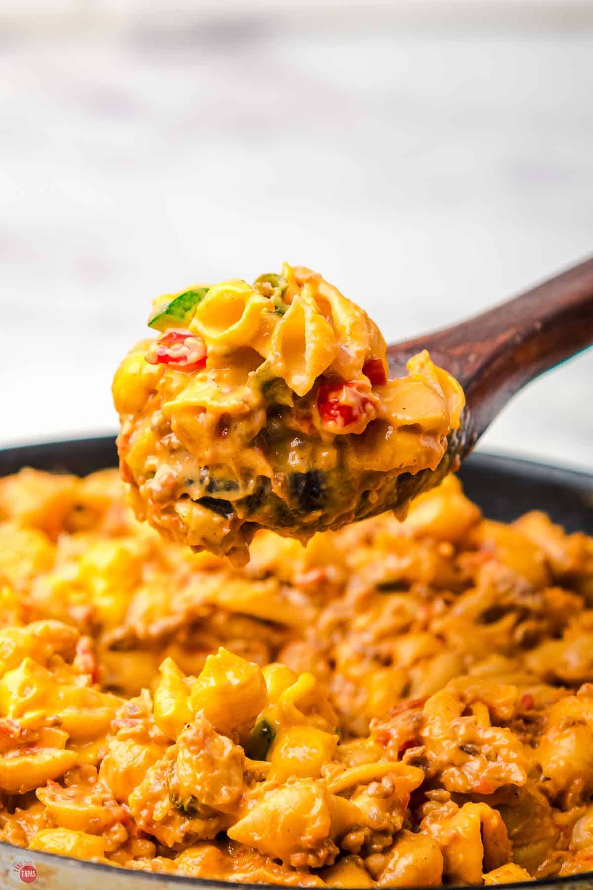 wood spoon with velveeta shells and peppers on it