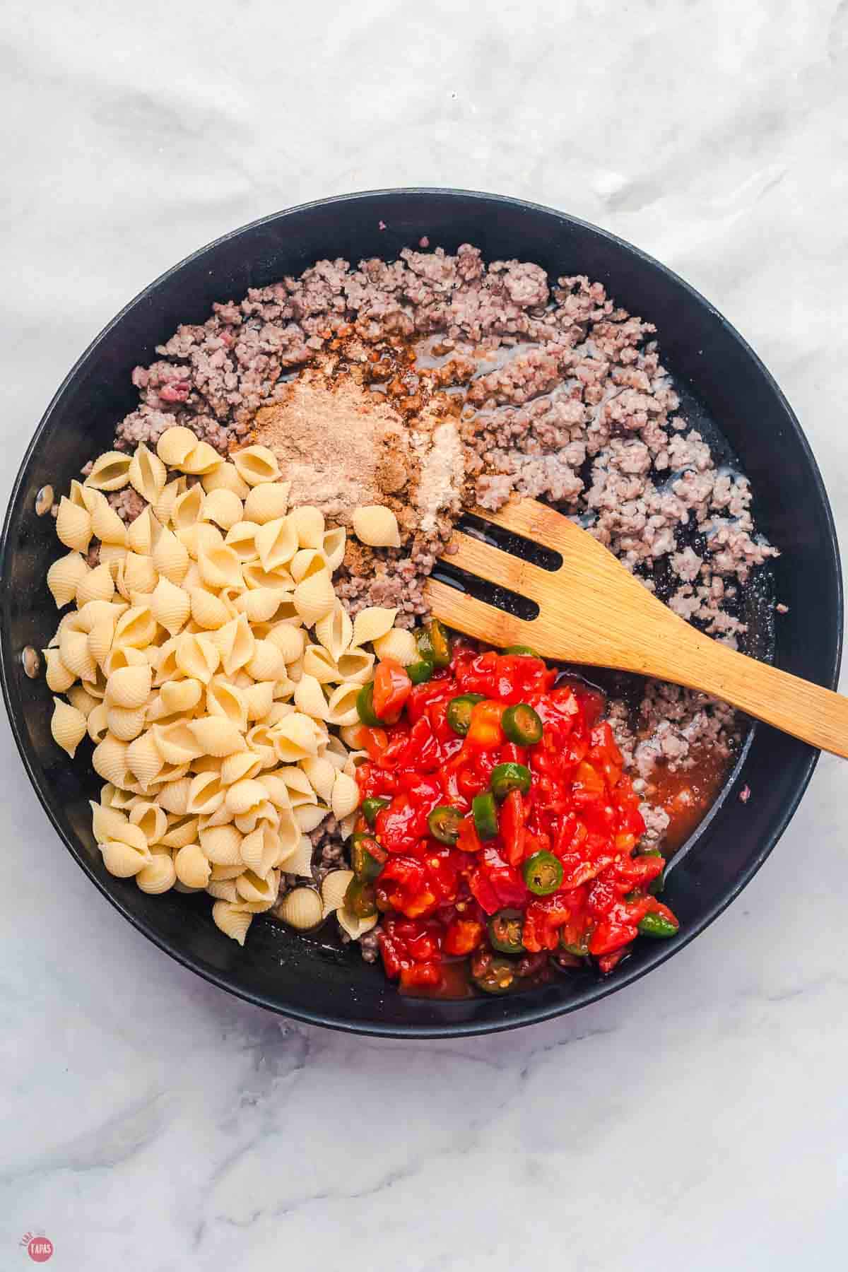 skillet with ground beef, shells, and rotel