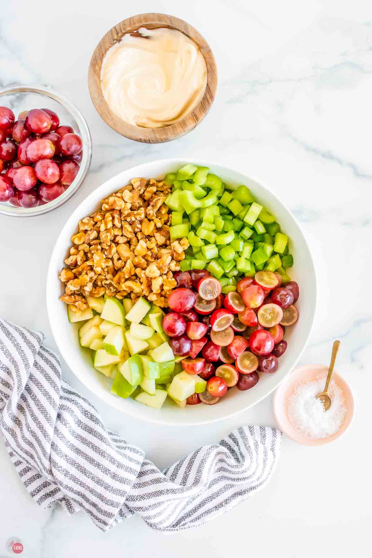 bowl with apples, nuts, celery, and walnuts in it