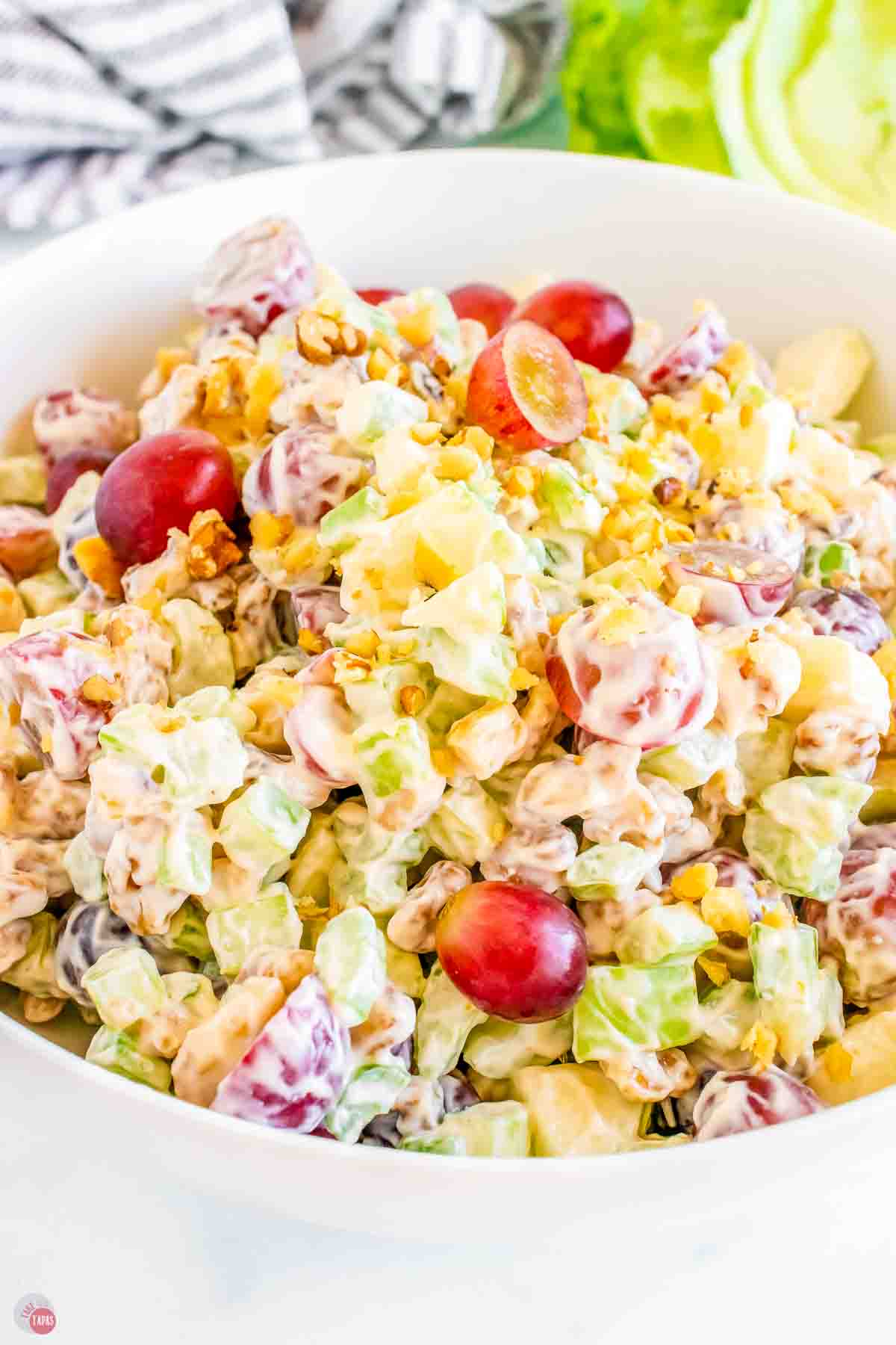 side view of top of waldorf salad in a white bowl