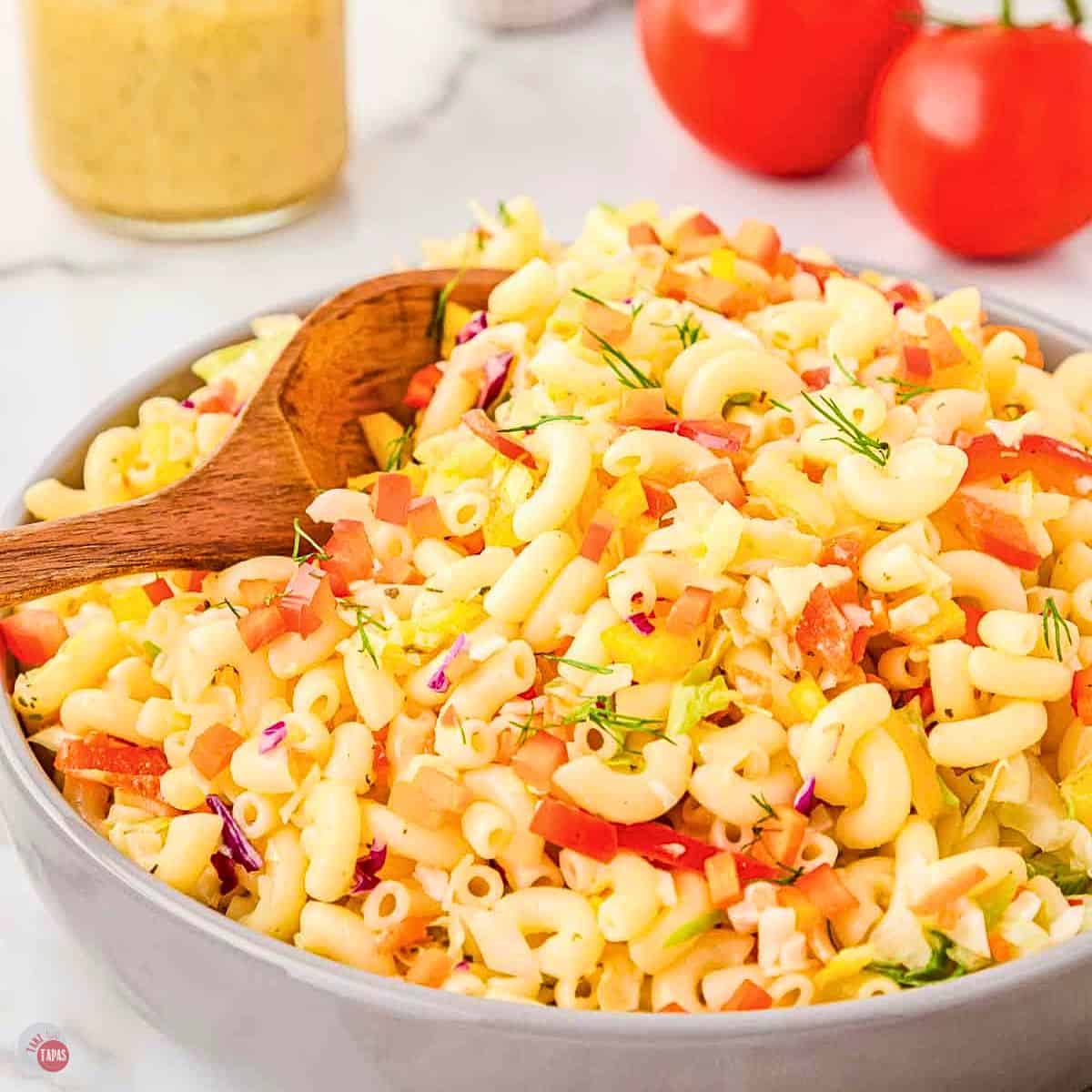 bowl of macaroni salad with wood spoon