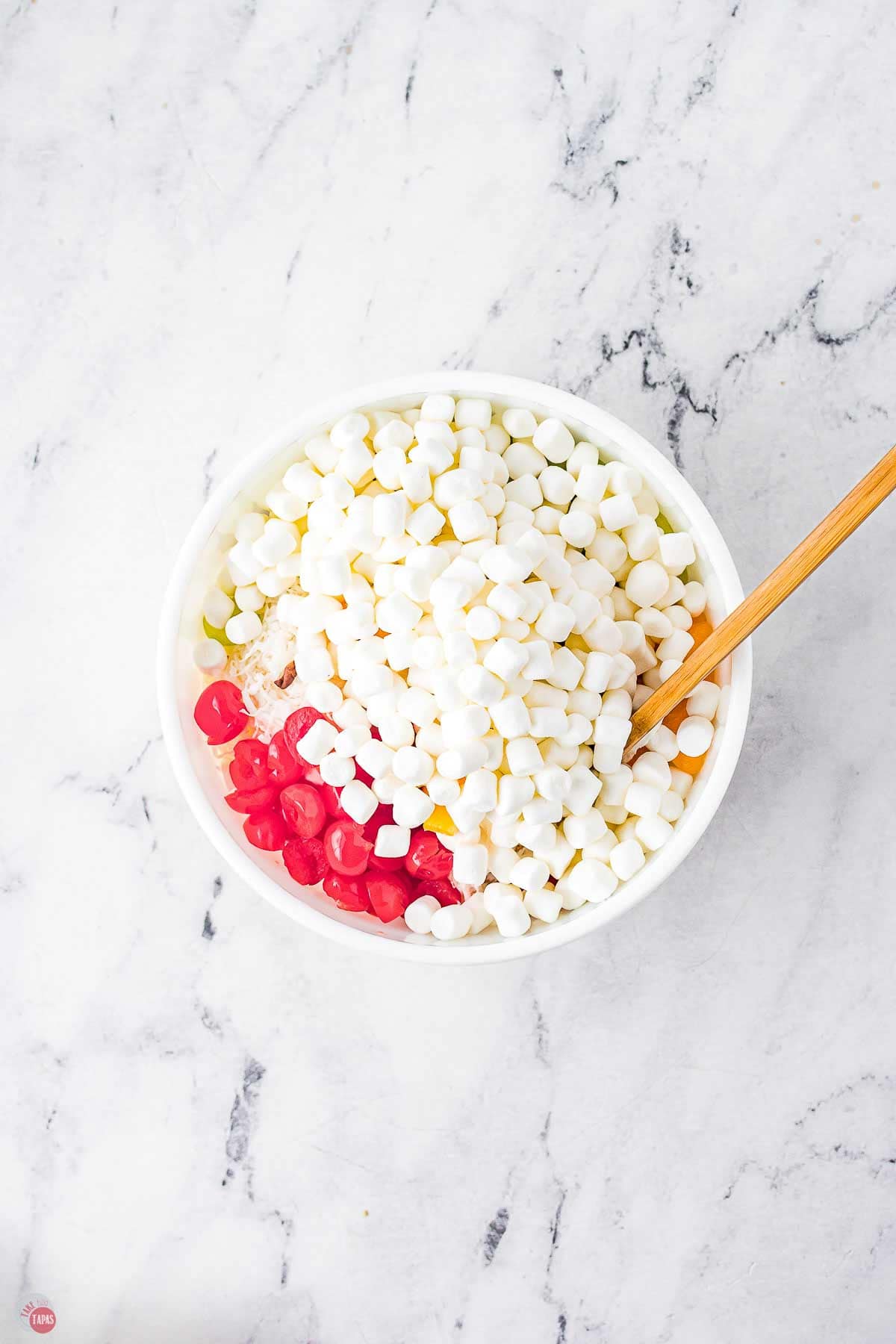 white bowl of marshmallows and red cherries