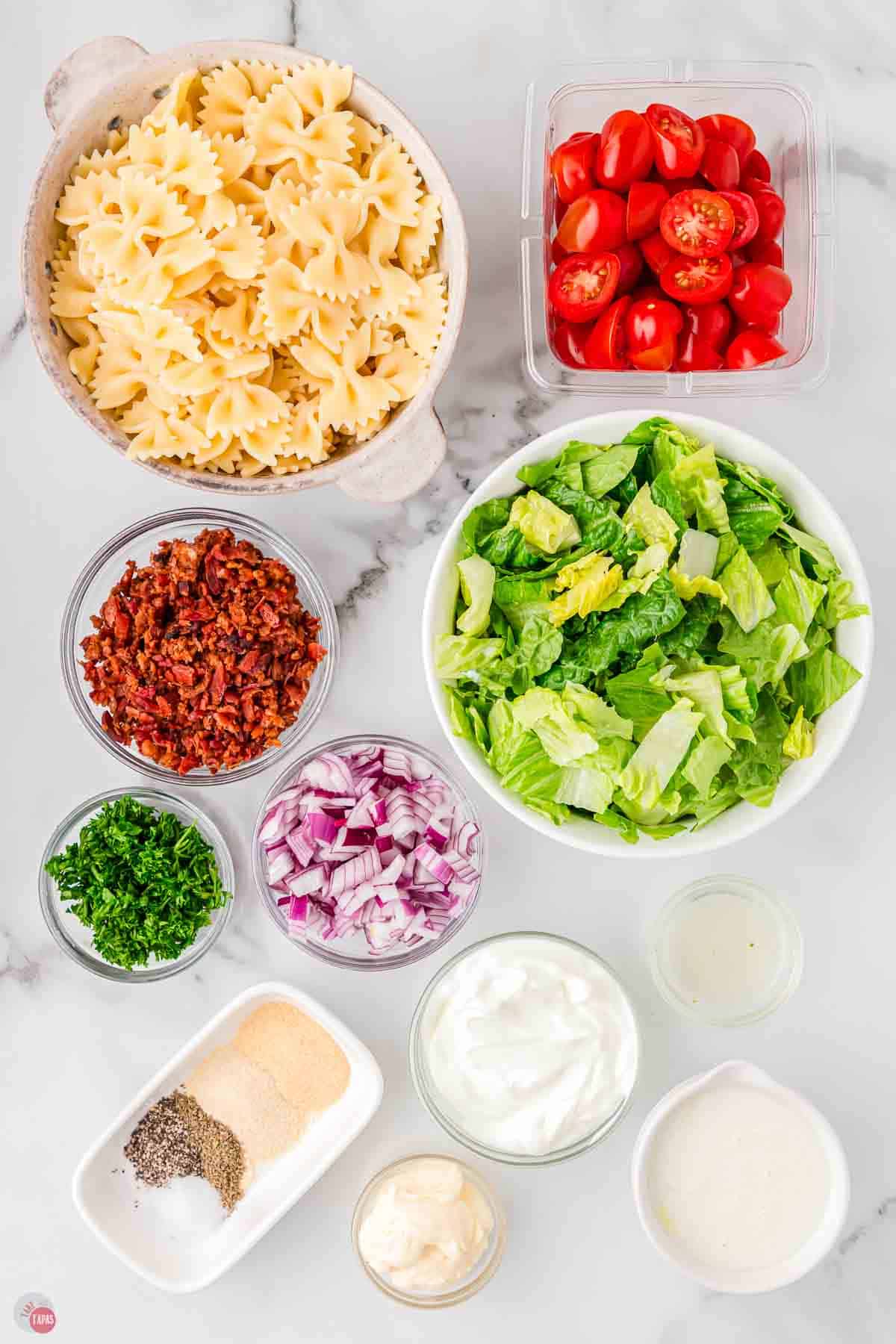 ingredients for a pasta salad prepped and stored into individual bowls