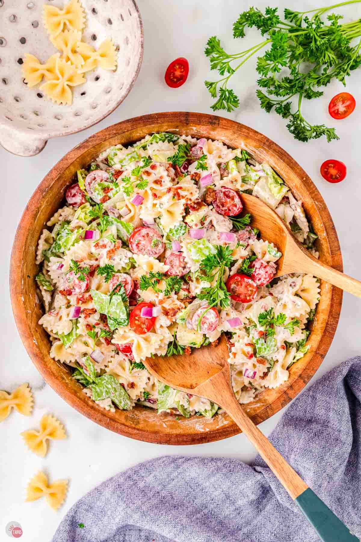 wood bowl of pasta salad with two spoons