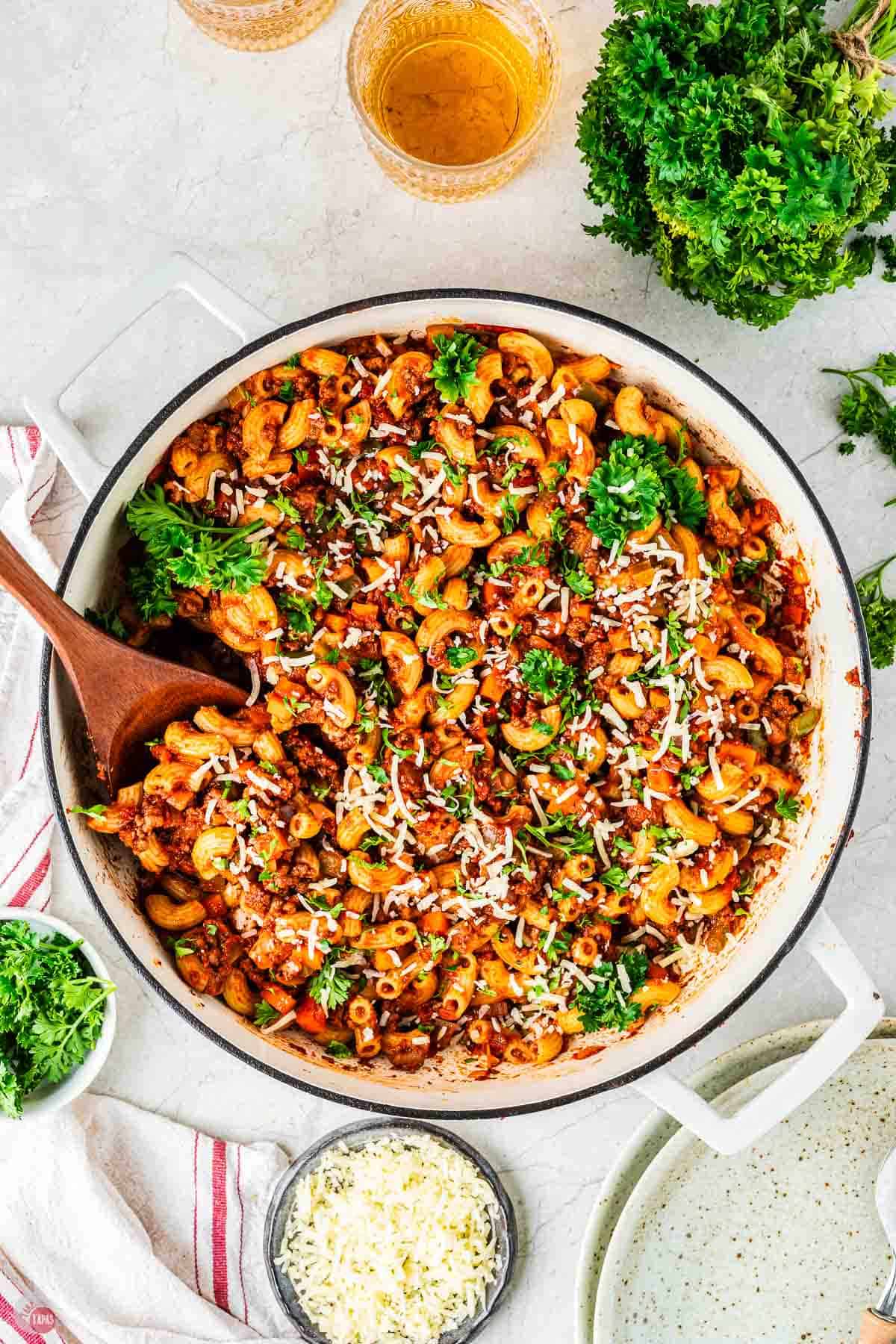 white pot of homemade beefaroni with a wood spoon
