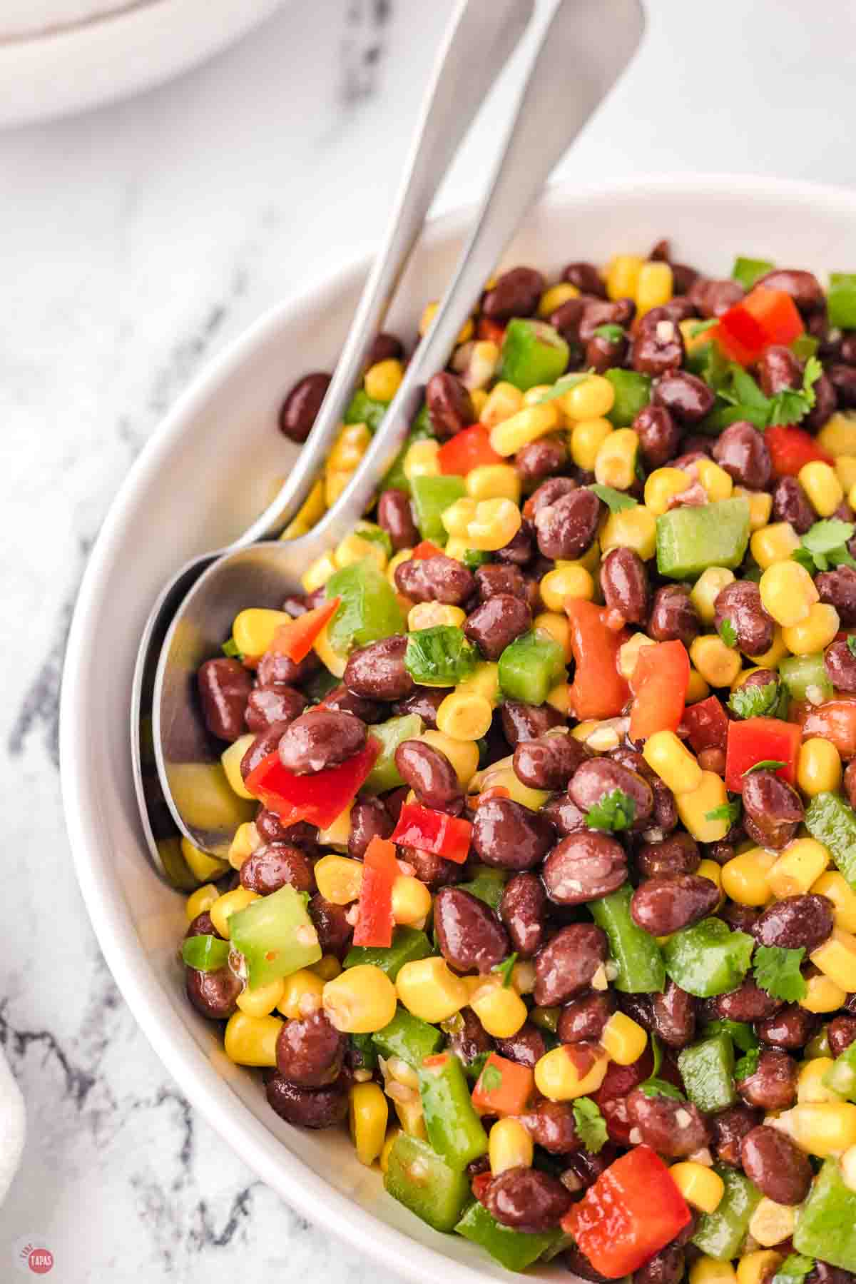 bowl of black bean and corn salad with two spoons