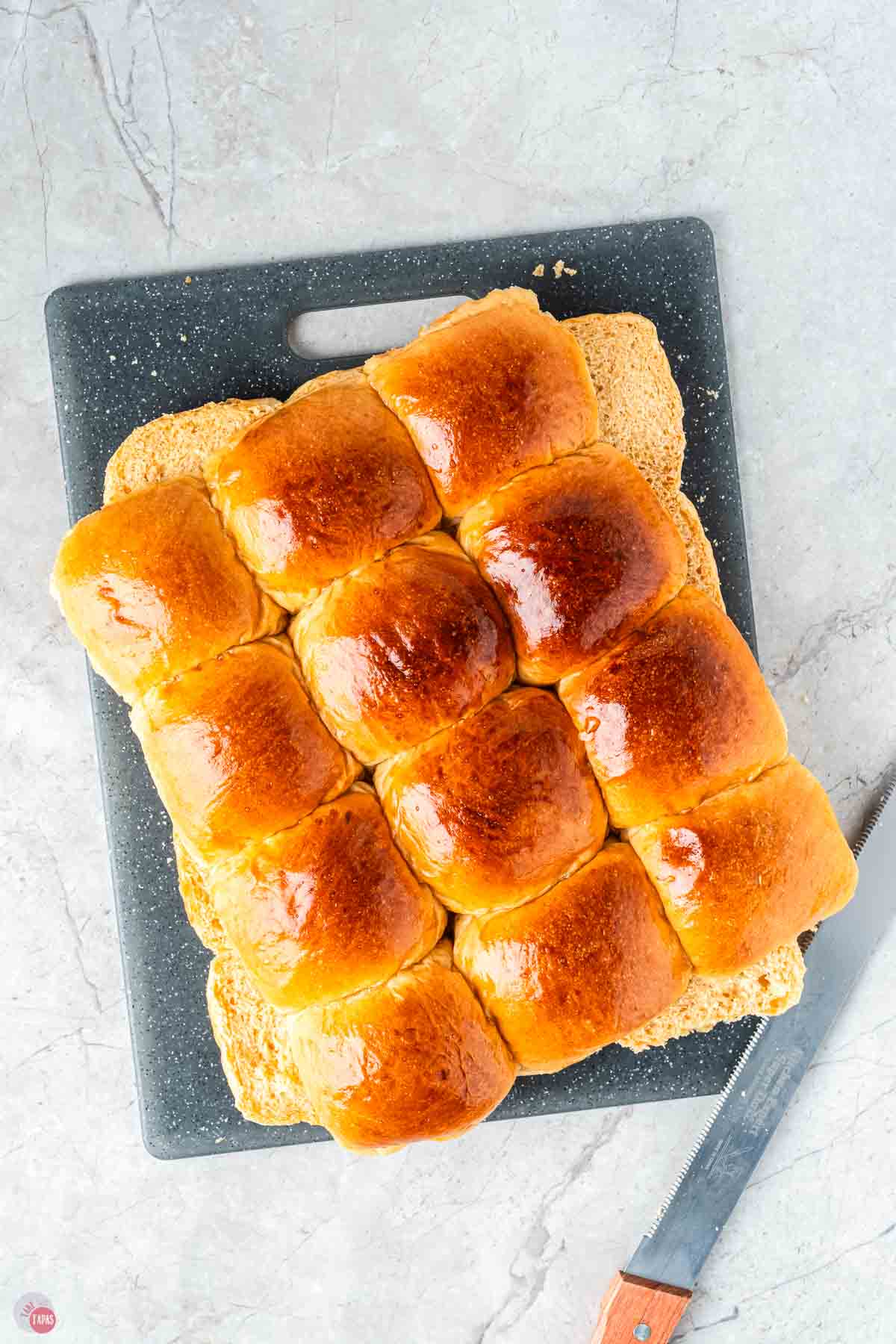 slider buns cut in half and stacked on a cutting board