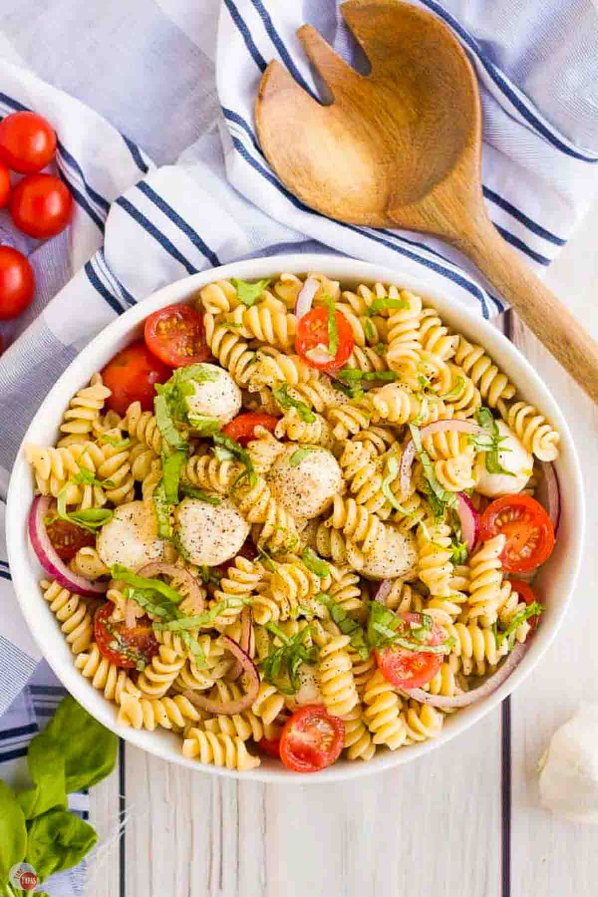 bowl of pasta salad with mozzarella, tomatoes, and basil