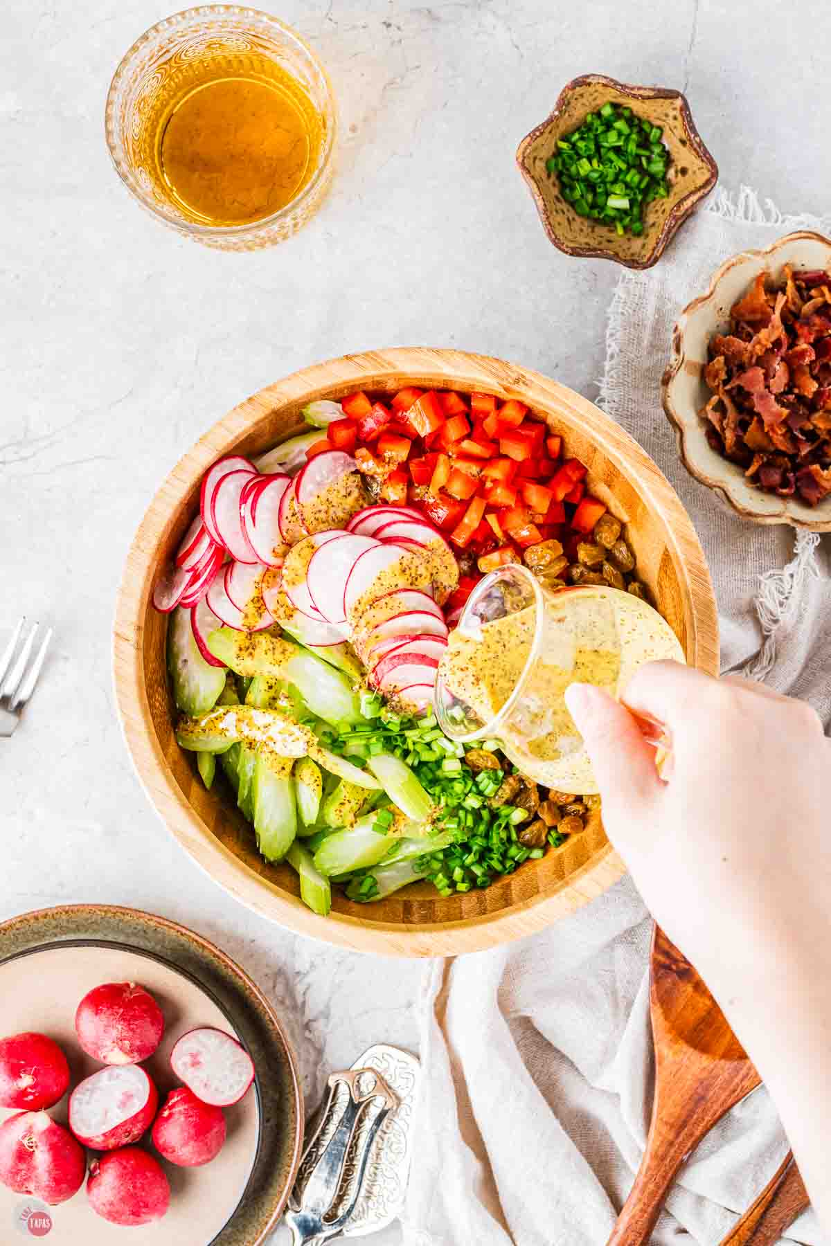 wood bowl full of sliced vegetables