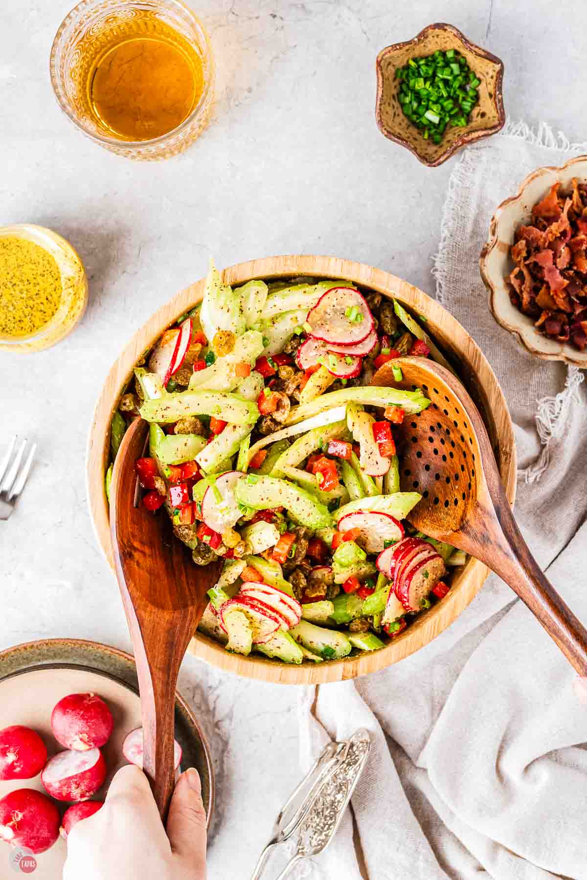 bowl of celery slaw with two wood spoons