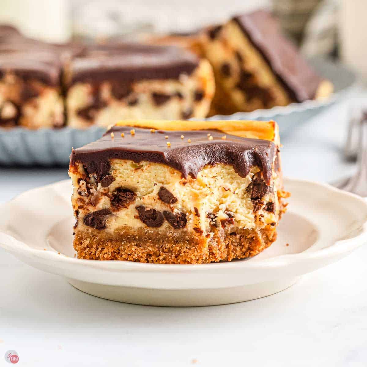 cheesecake bar with chocolate chips on a plate with a bite missing