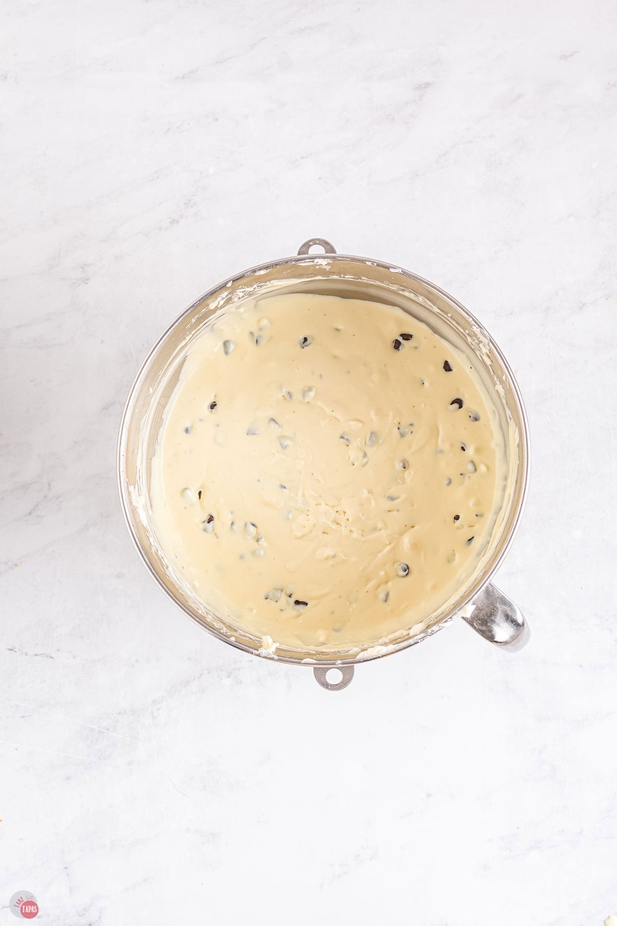 chocolate chip cheesecake mixture in a silver mixing bowl
