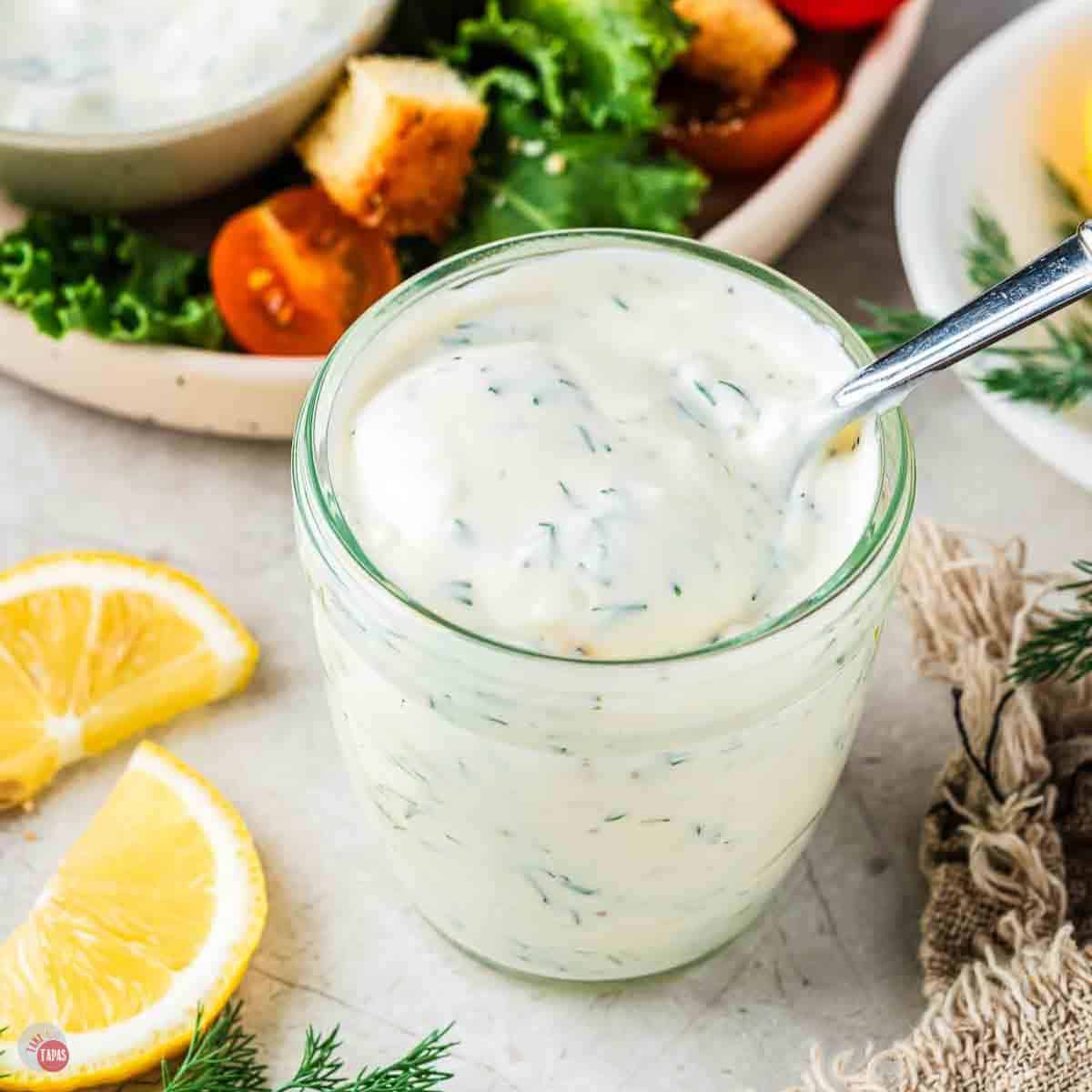 small jar of creamy salad dressing with a spoon in it