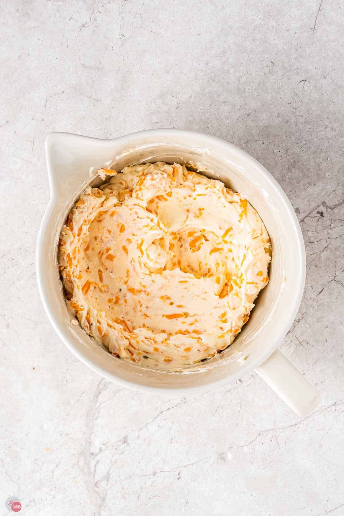 bowl of cream cheese and shredded cheese mixed together