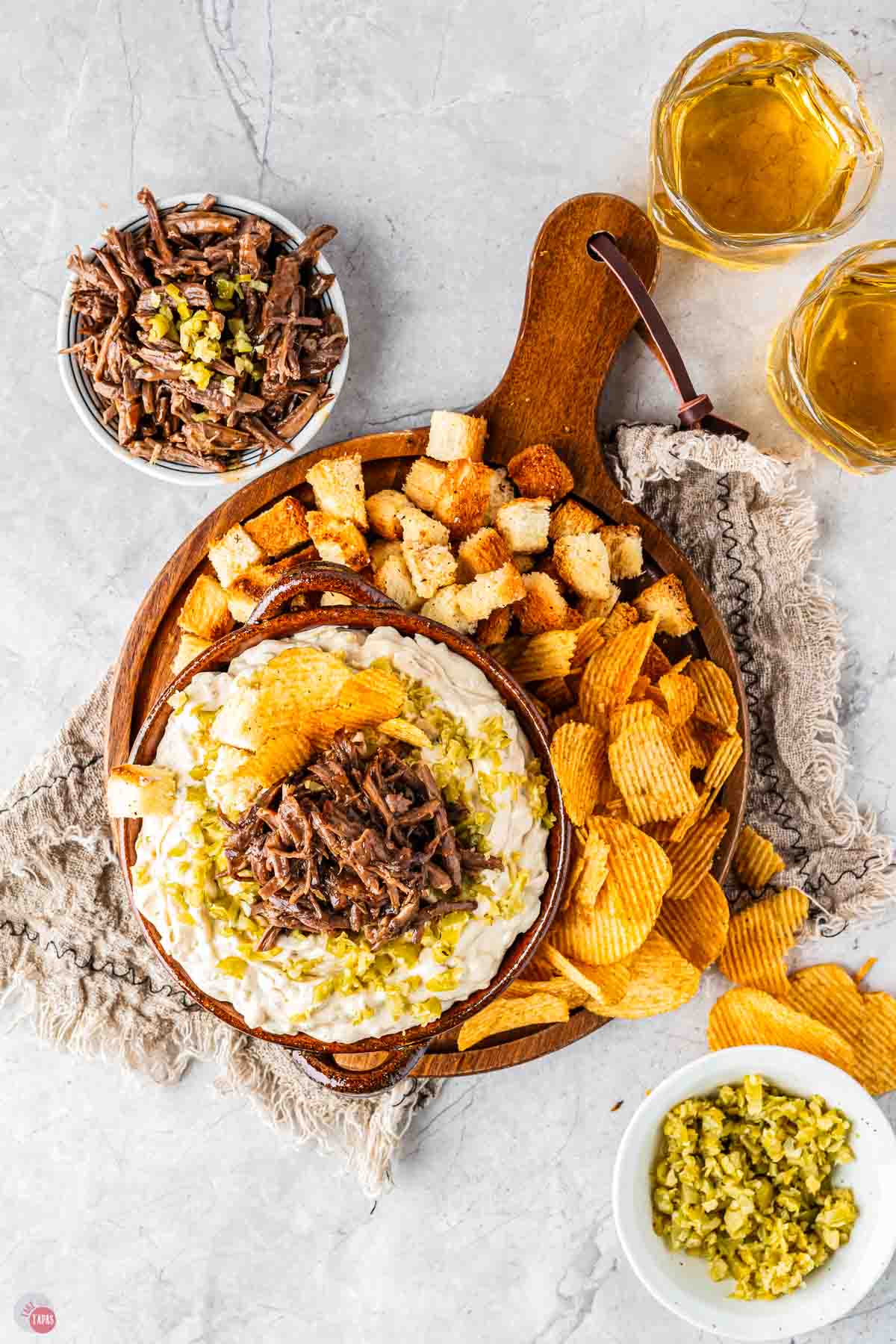 wood serving platter with crackers and dip on it