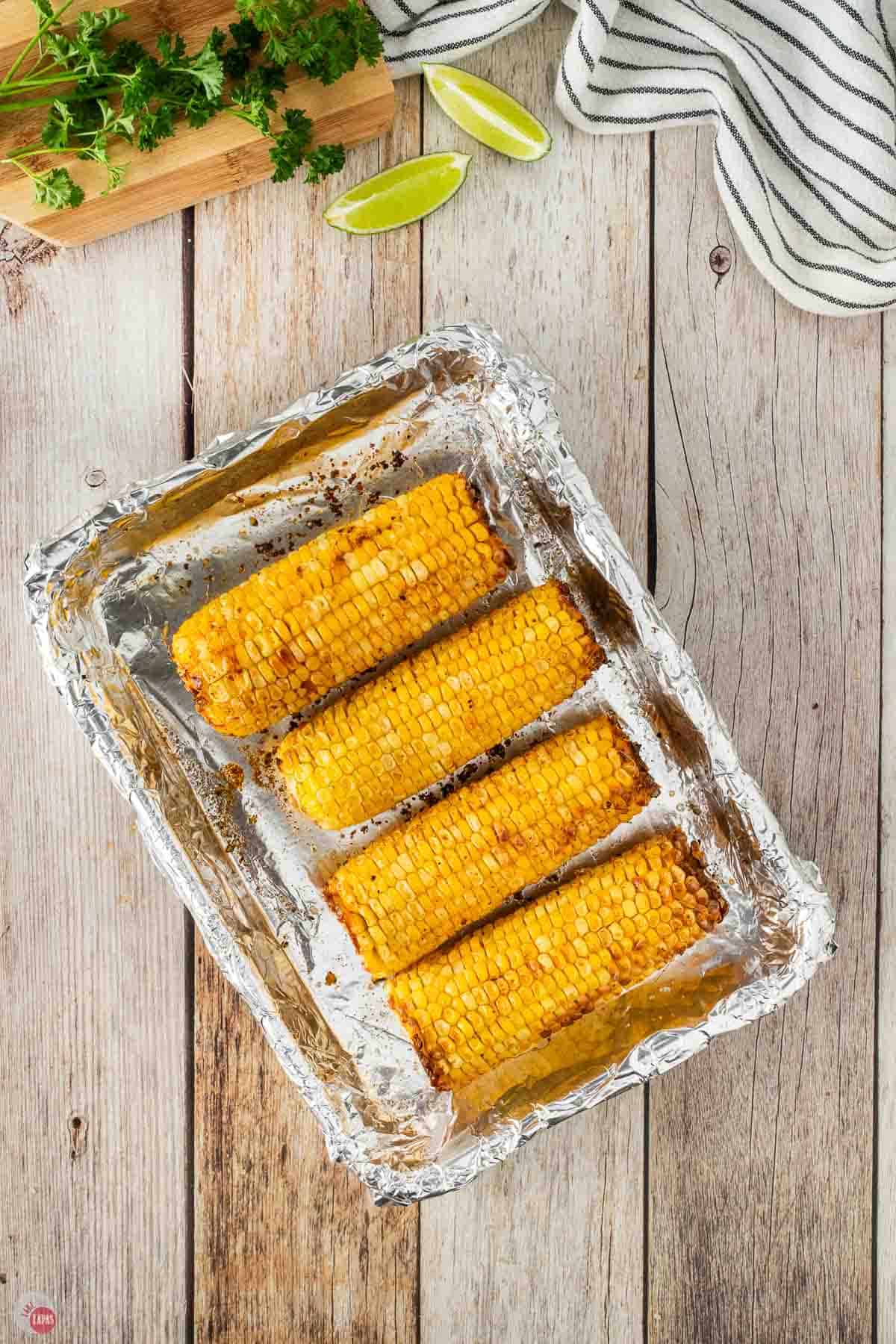 roasted corn cobs on a foil-lined baking sheeet