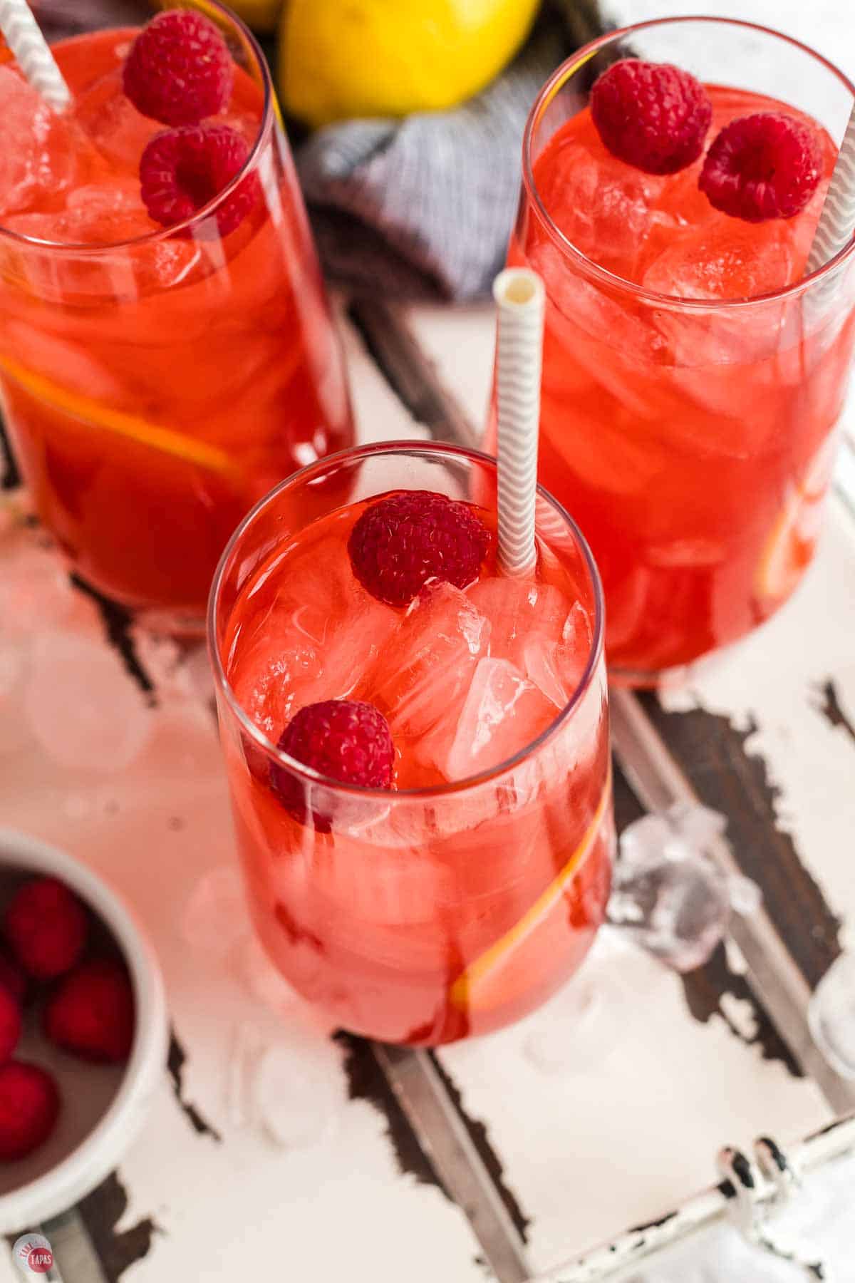 close up of glass of fruity iced tea with a striped straw