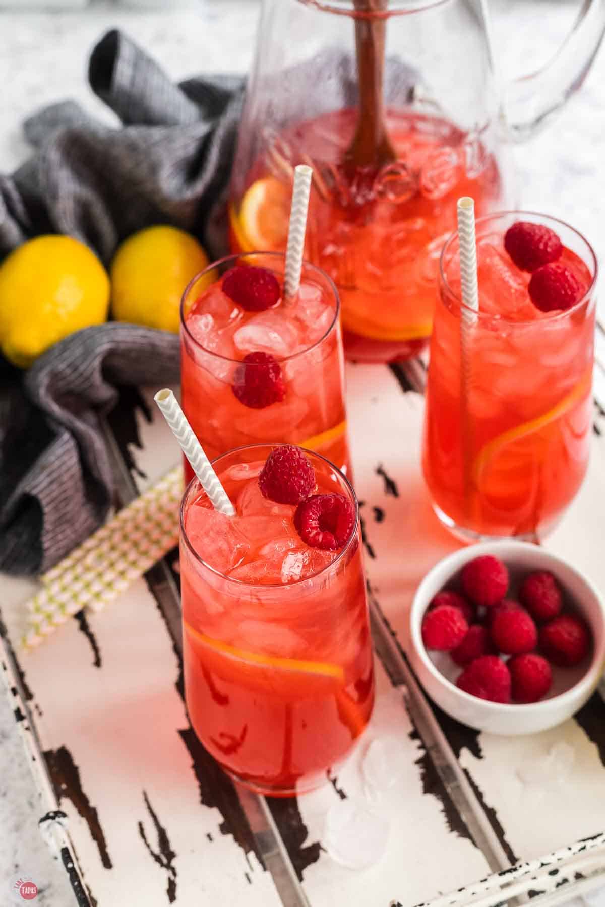 3 glasses of raspberry iced tea on a white tray
