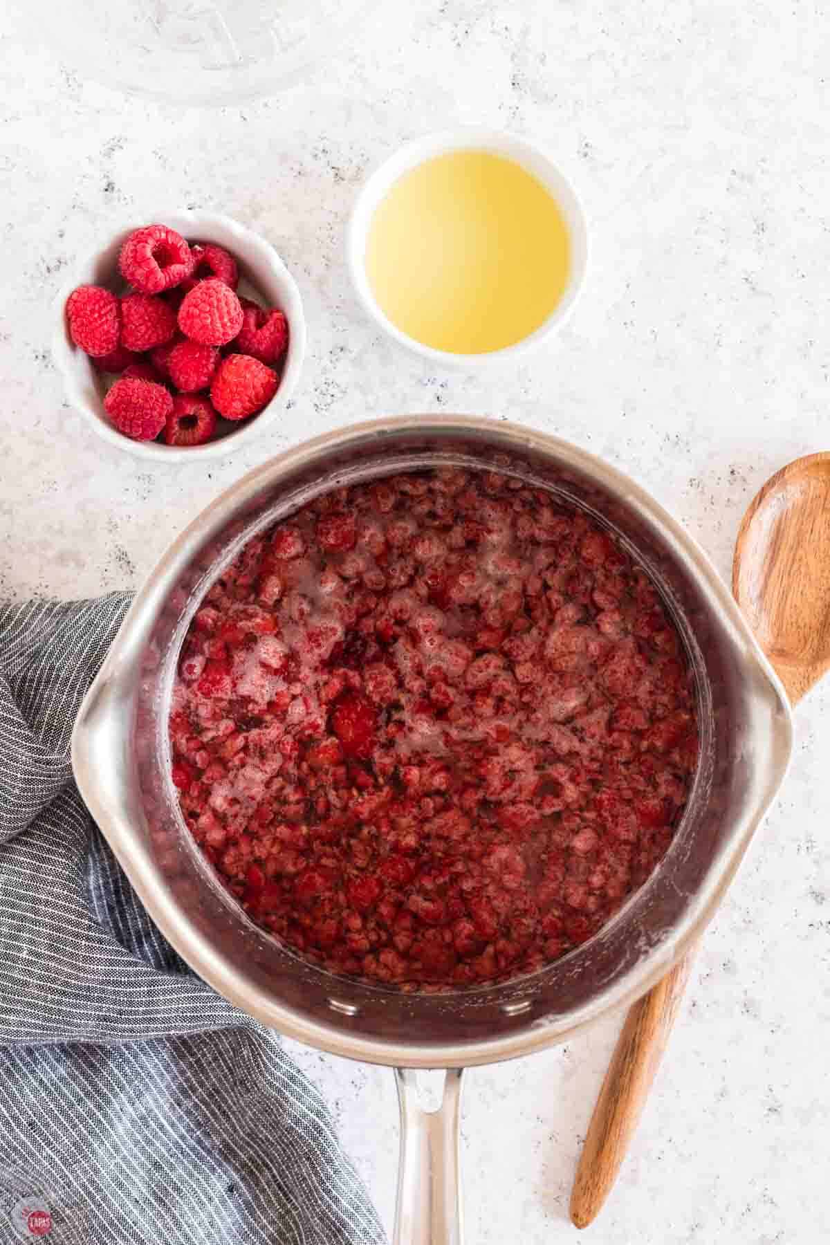 raspberries and sugar boiling in water.