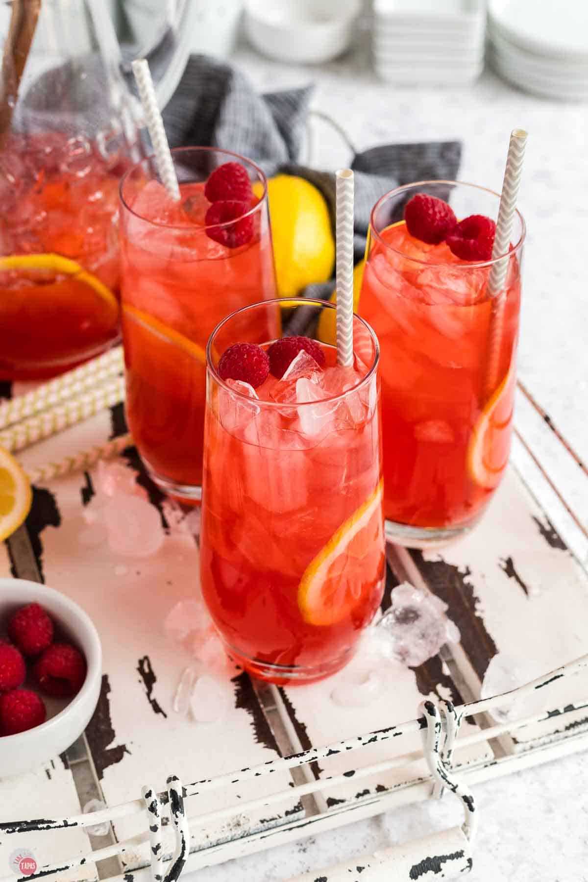glasses of pink drink with berries and lemon