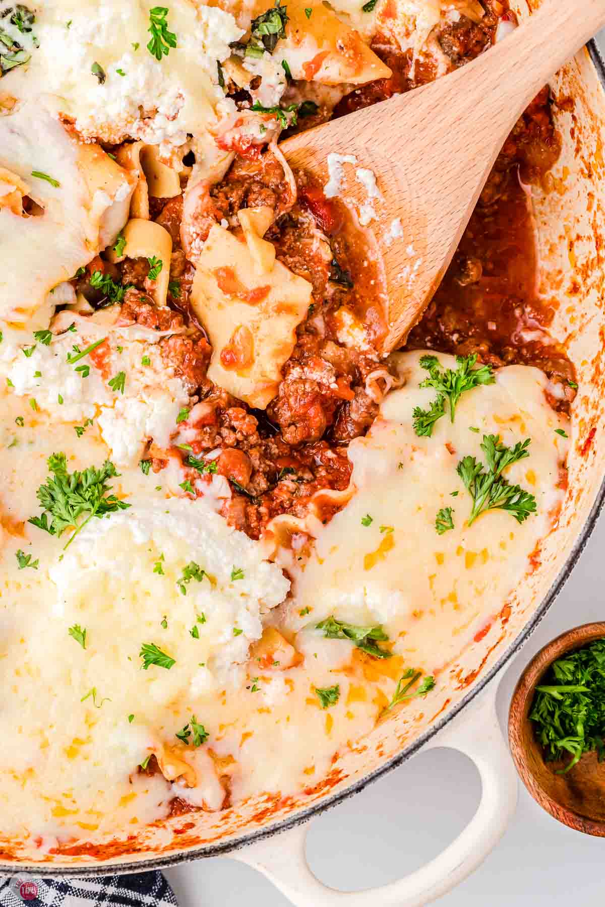 skillet with meat sauce and lasagna noodles topped with cheese