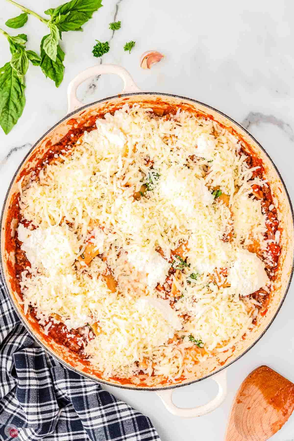 skillet of tomato sauce topped with two kinds of cheeses