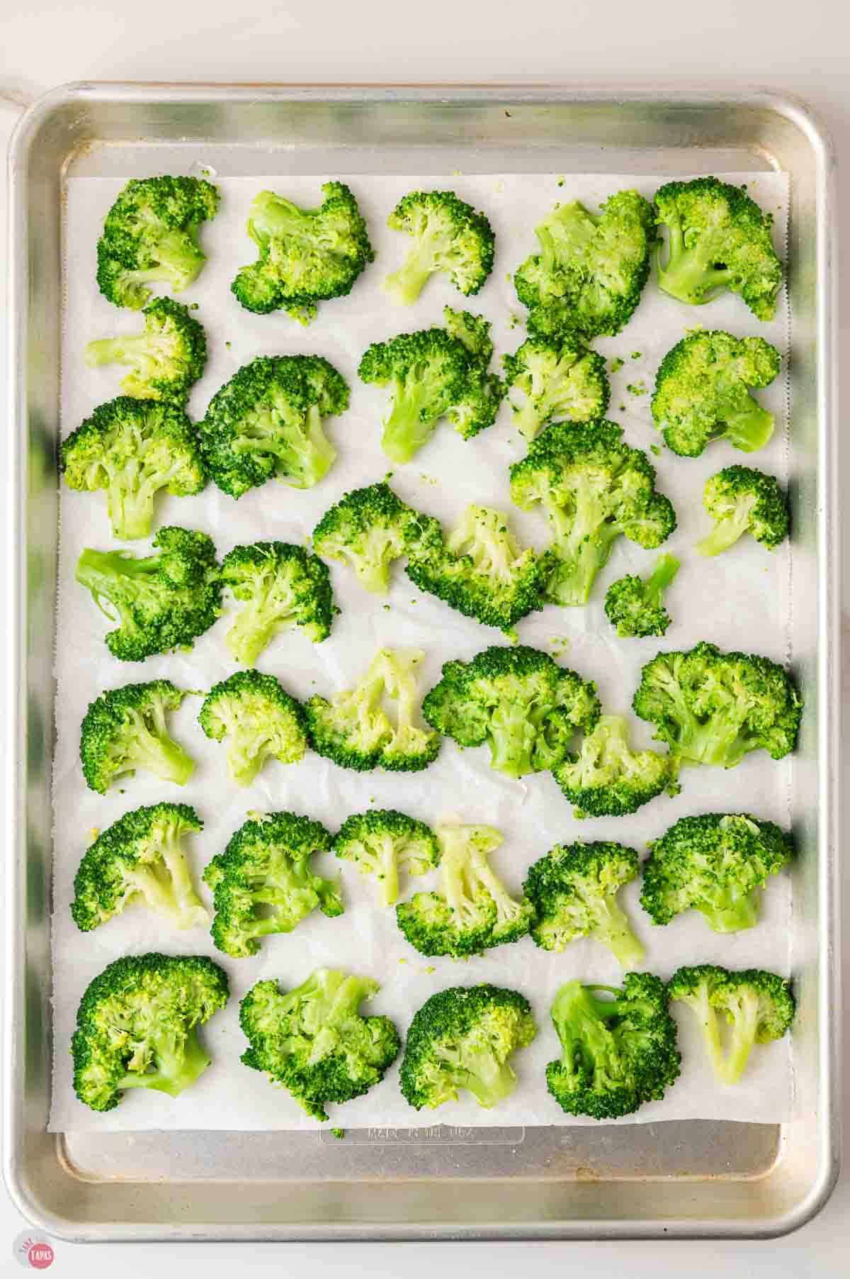 baking sheet of broccoli florets that are smashed flat