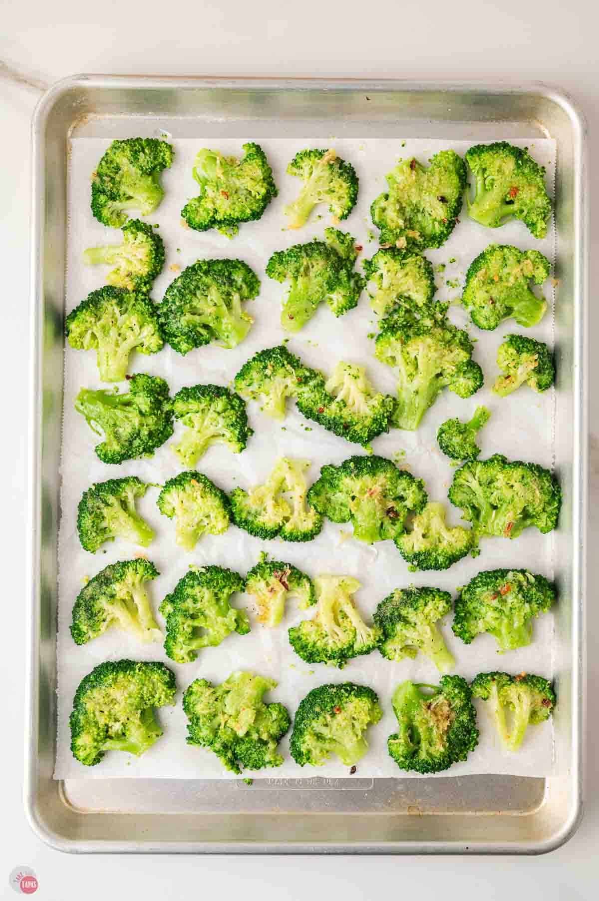 baking sheet of roasted broccoli topped with parmesan cheese