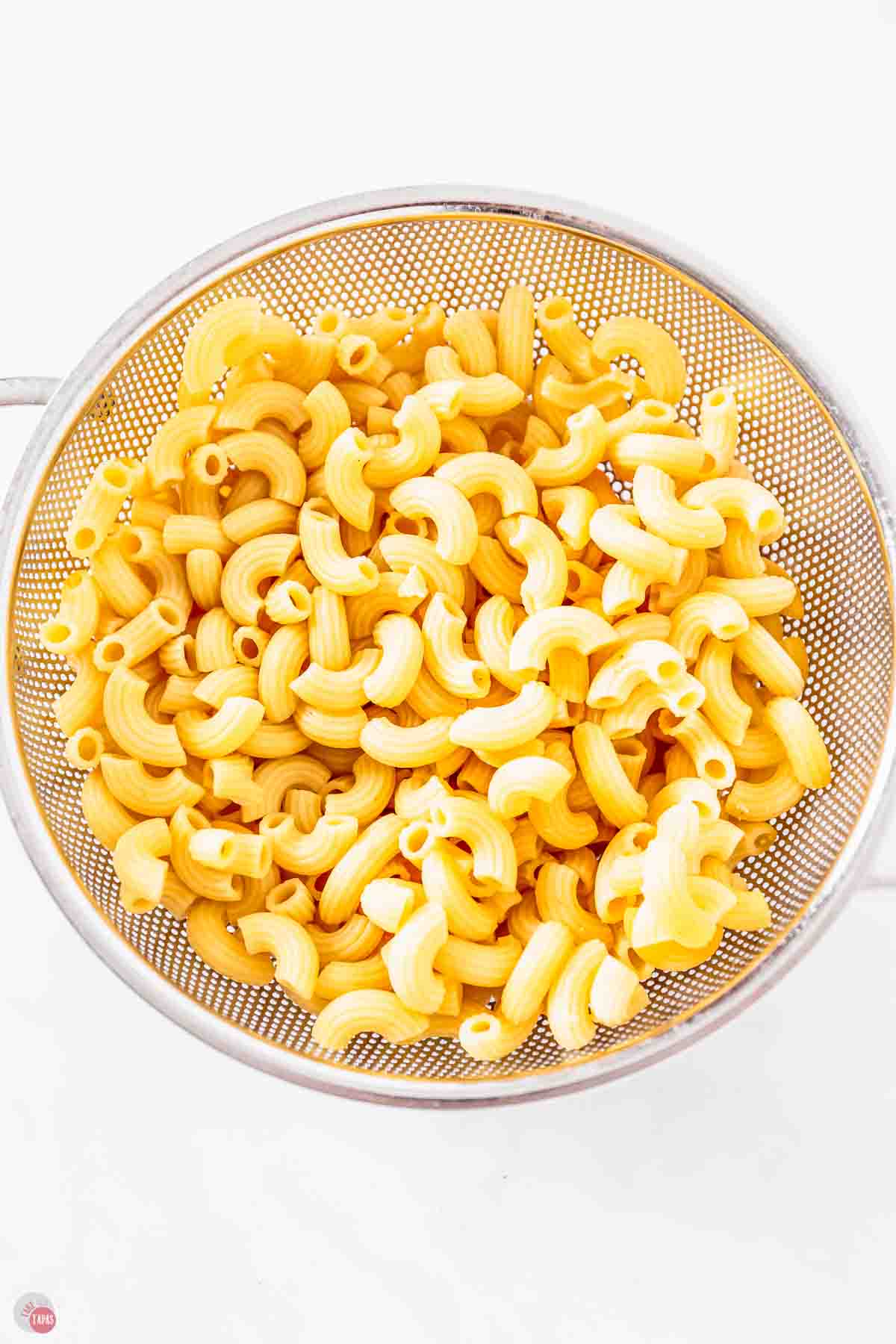 cooked elbow macaroni in a silver strainer