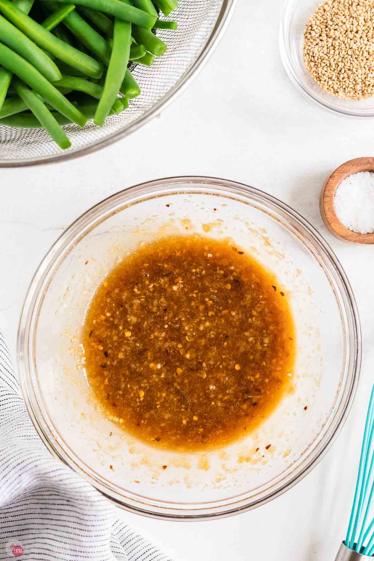 bowl of ginger garlic sauce next to a bowl of beans