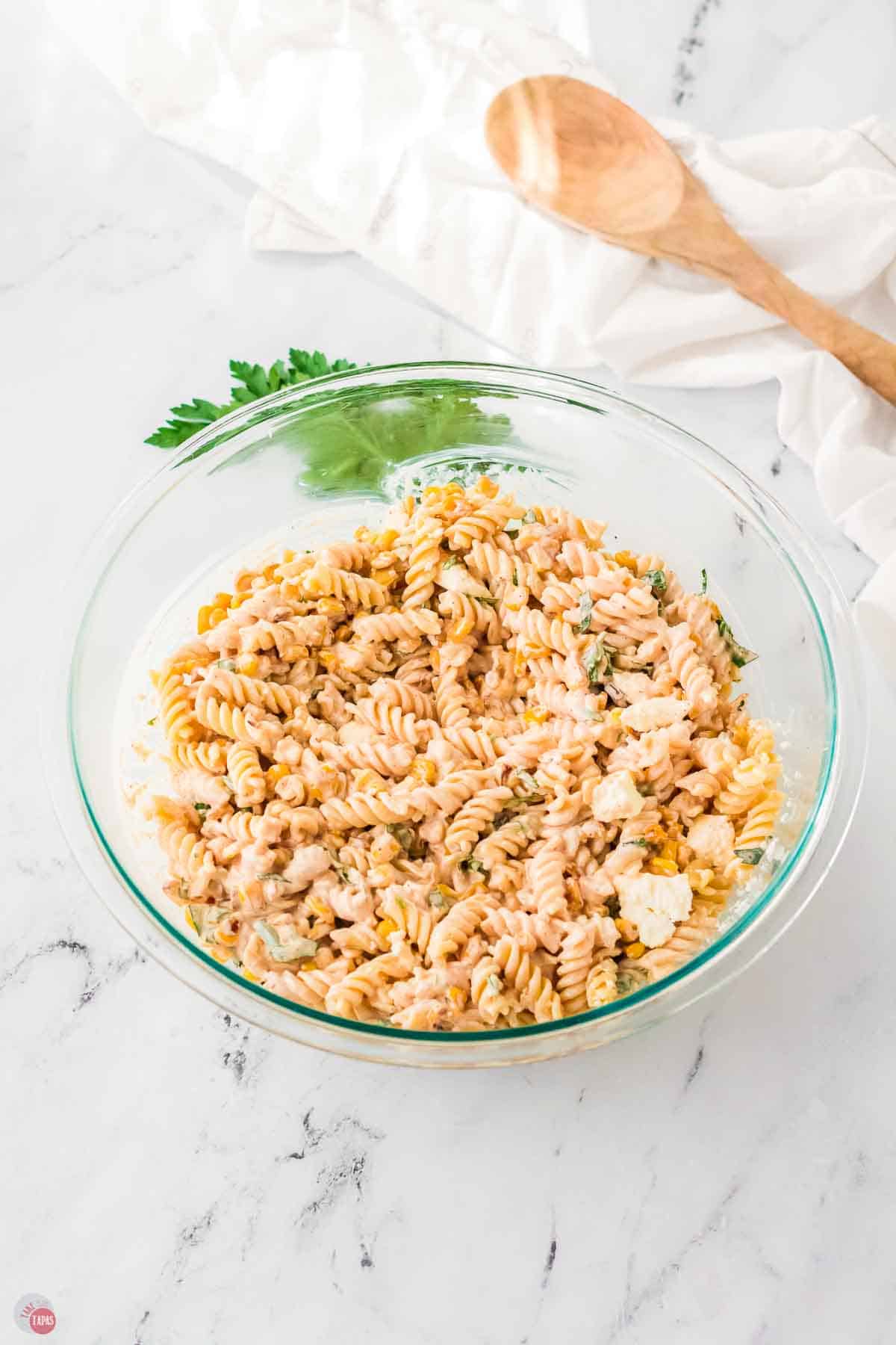 bowl of pasta mixed with vegetables and a creamy dressing
