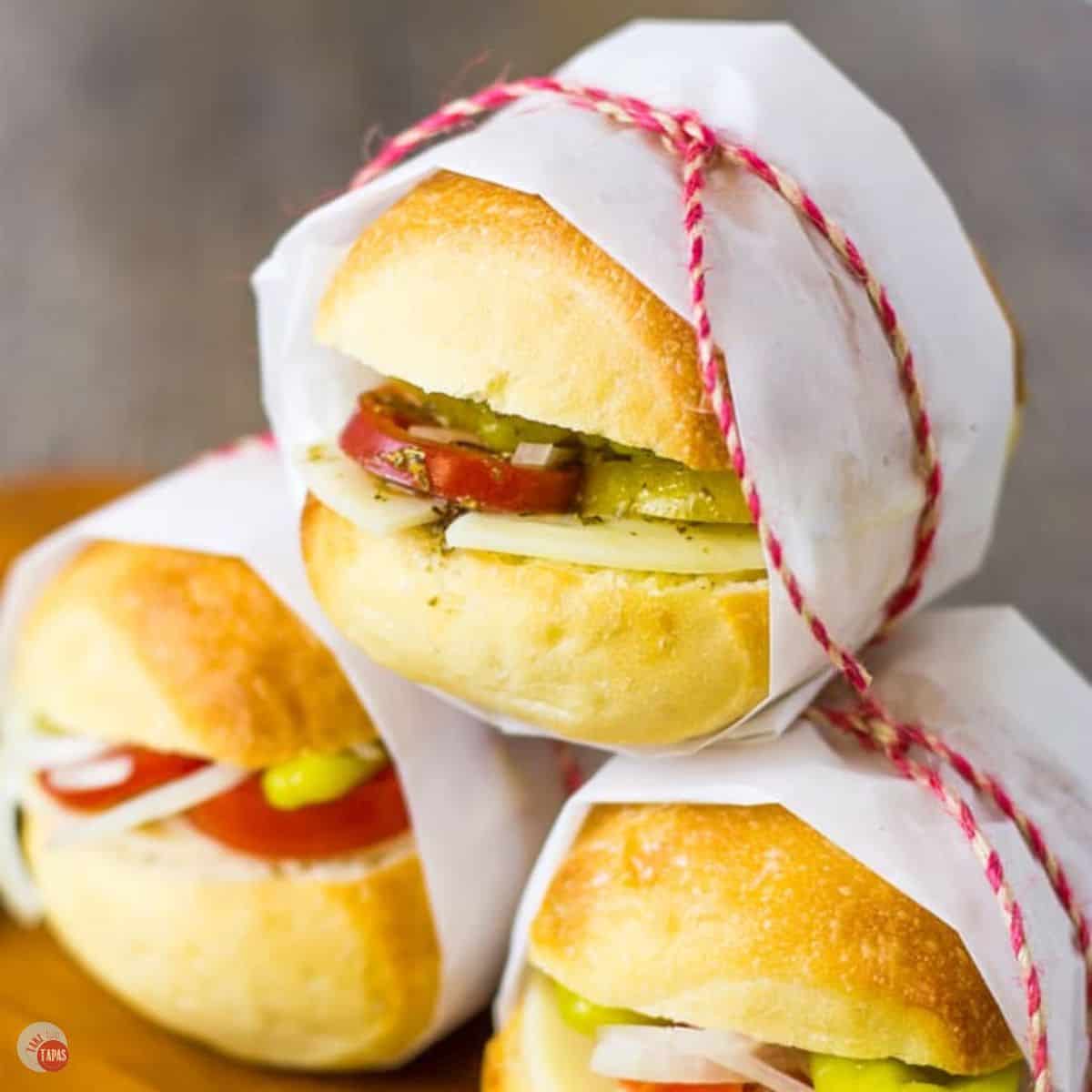 stack of wrapped sandwiches in parchment paper