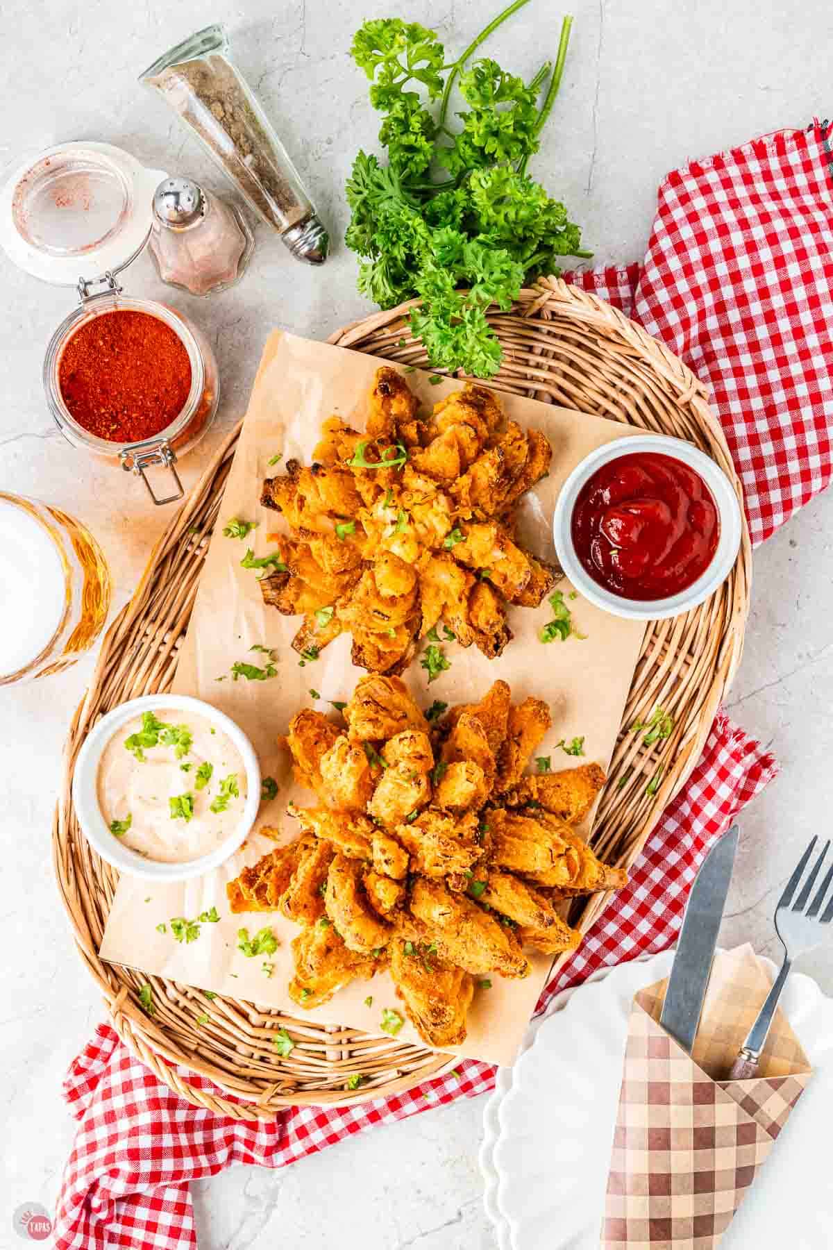 overhead picture of two blooming onions on a wicker tray