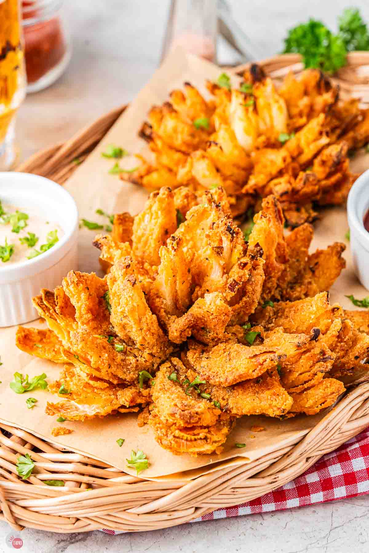 close up of air fried onions on a wicker tray