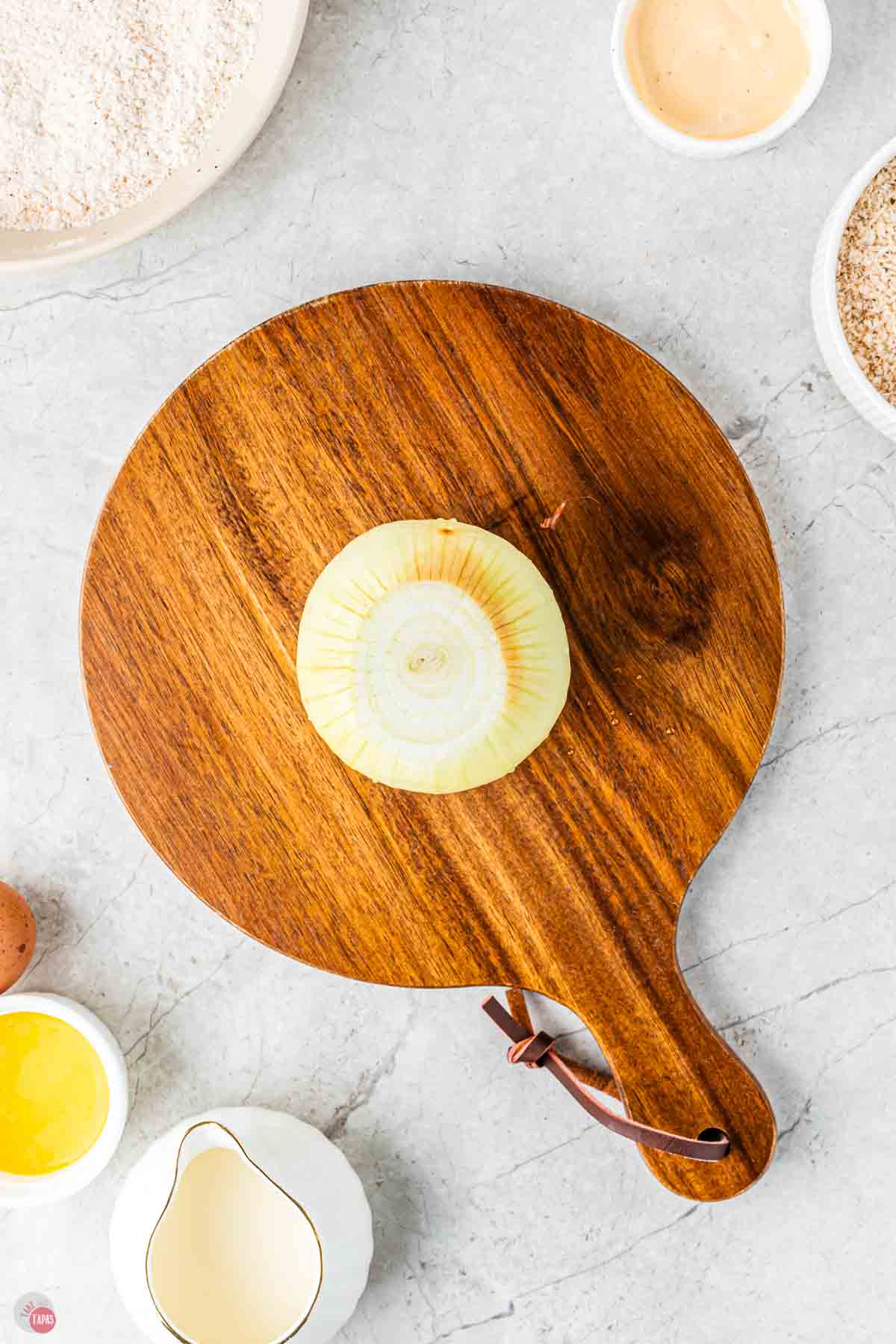 onion on a cutting board the the ends removed