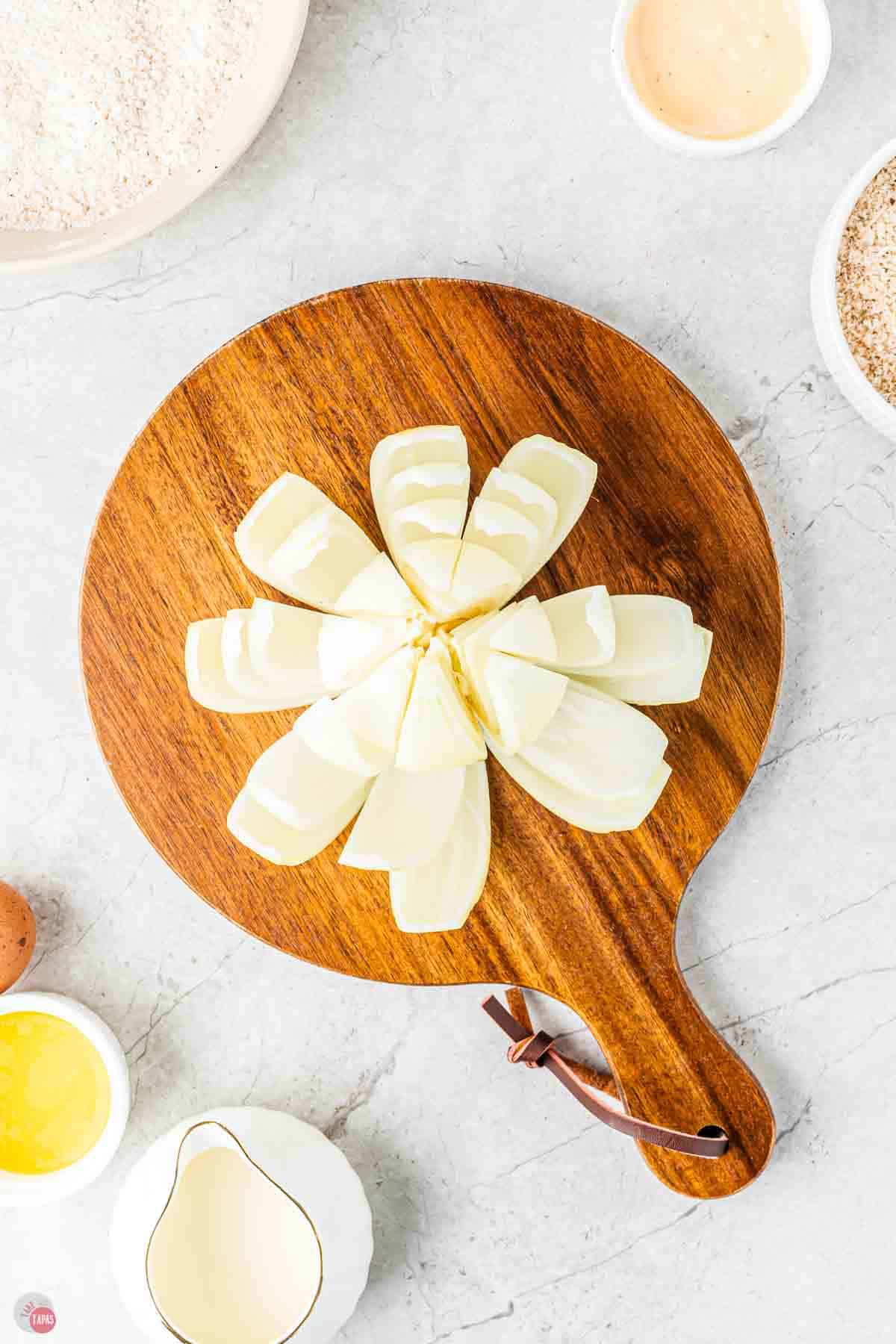 onion on a cutting board with the layers spread onion like it's a blooming flower
